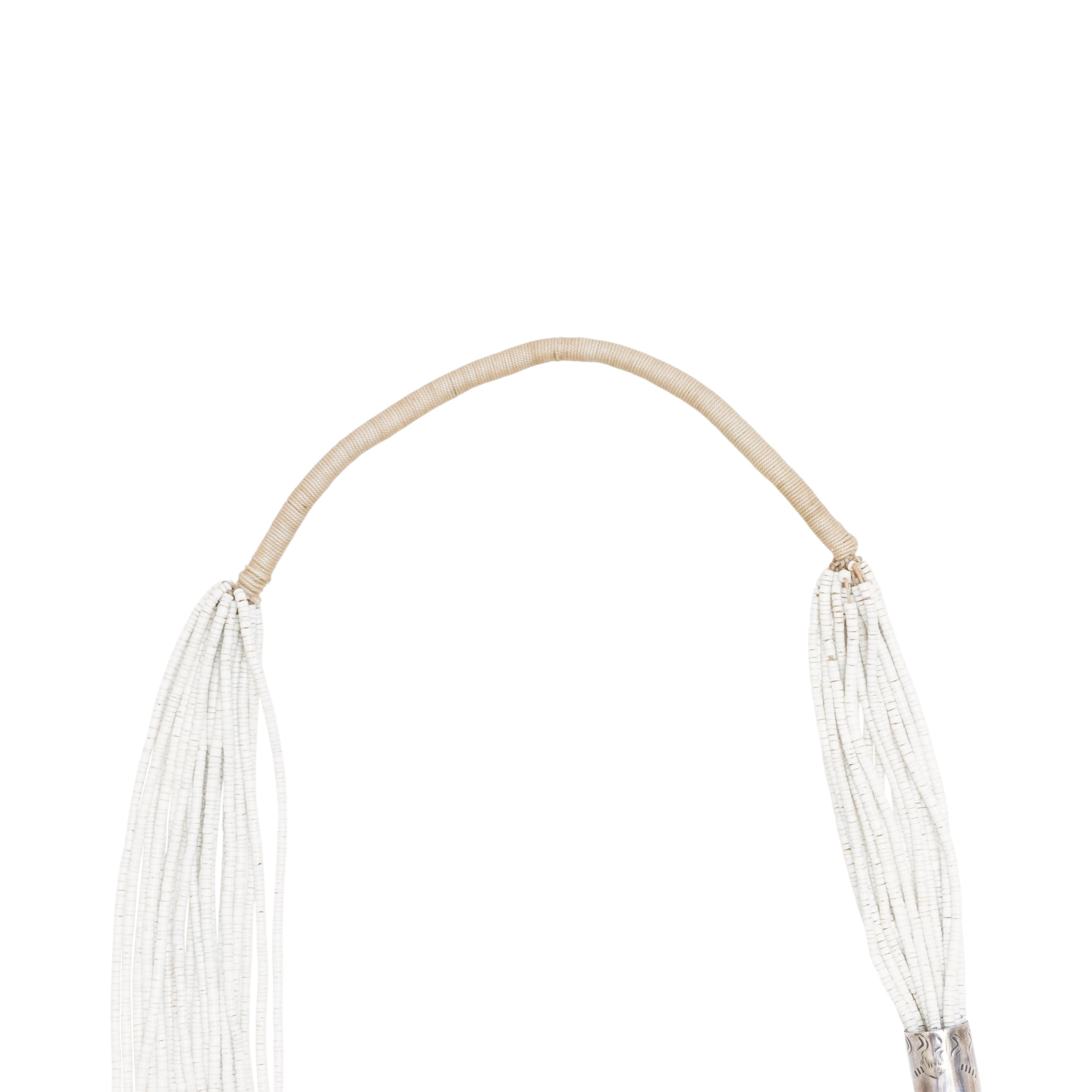 Pueblo Heishi glass bead necklace with coral. Pueblo, Mid-20th century. A stunning necklace comprised of cotton threads strung with hundreds of tiny heishi glass beads, with one side longer than the other. Both bundles of threads attach to sterling