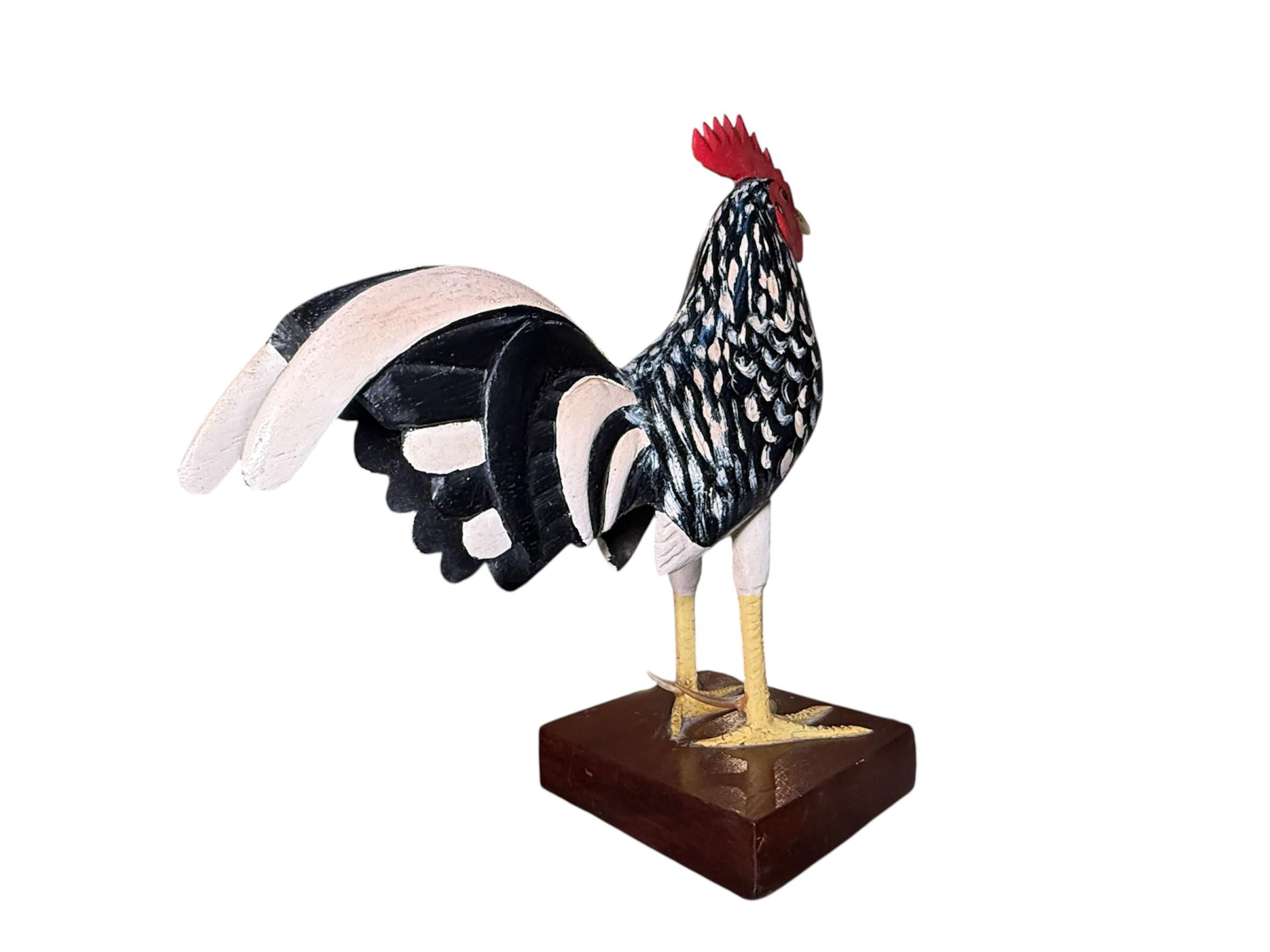This is a Puerto Rican Hand Crafted Wood Pair of Roosters Sculptures by Emilio Rosado. It depicts a hand carved and hand painted white, red, yellow and black color standing proud and tall rooster and his chicken. They are supported by individual