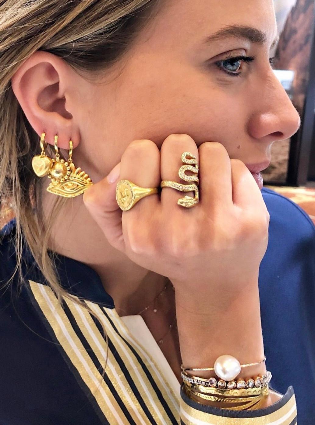 The puffy heart hoops are designed by Christina Alexiou. 
This pair of hoop earrings are crafted with 18k gold and are made in Greece. The hearts are hollow, thus makes this pair of earrings an easy-to-wear everyday piece of jewelry. This piece