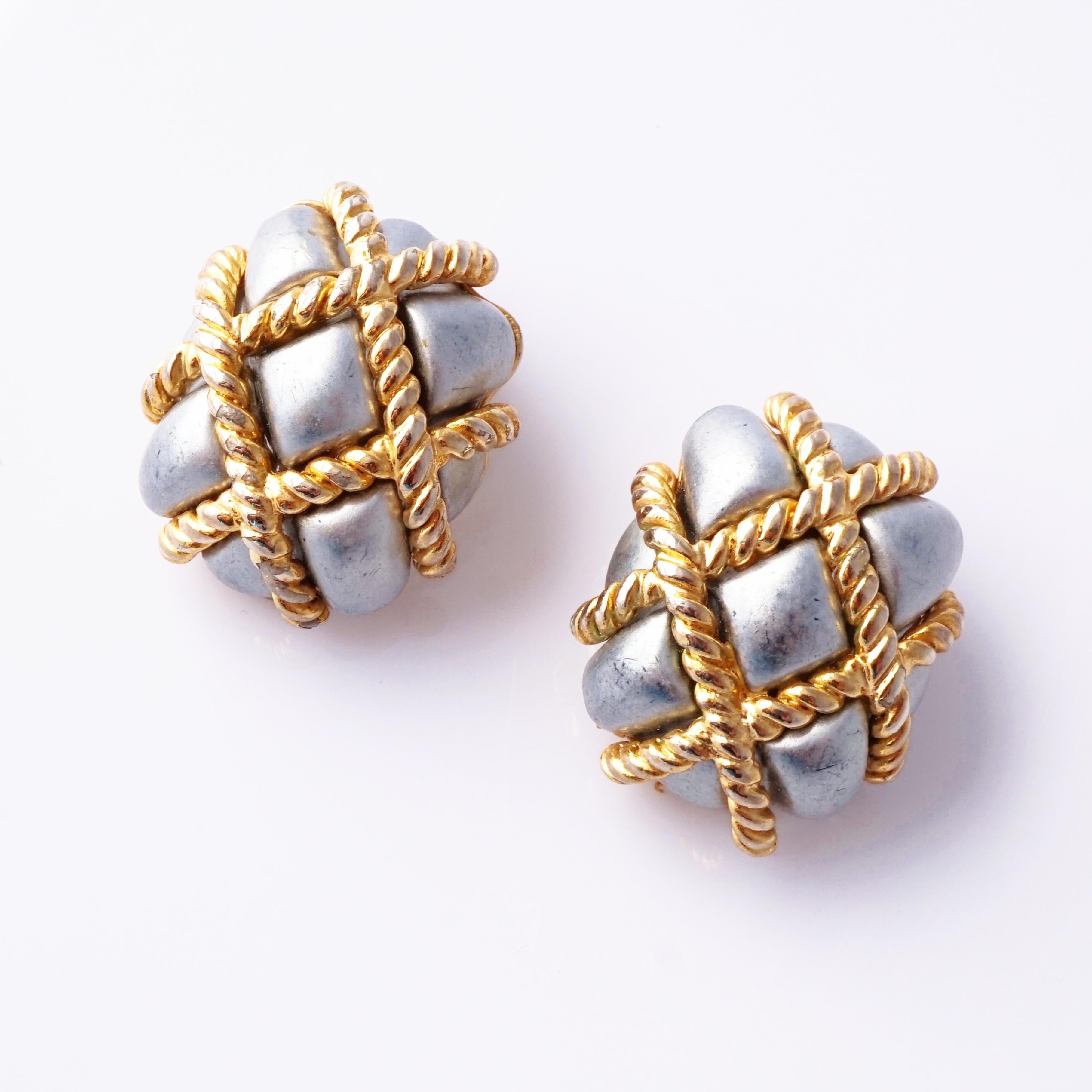 Iconic and effortlessly chic, these 1980s Kenneth Jay Lane earrings are the epitome of statement sophistication. Featuring quilted silver resin wrapped in crisscrossing gold rope detailing, they blend luxe texture with timeless design. The bold