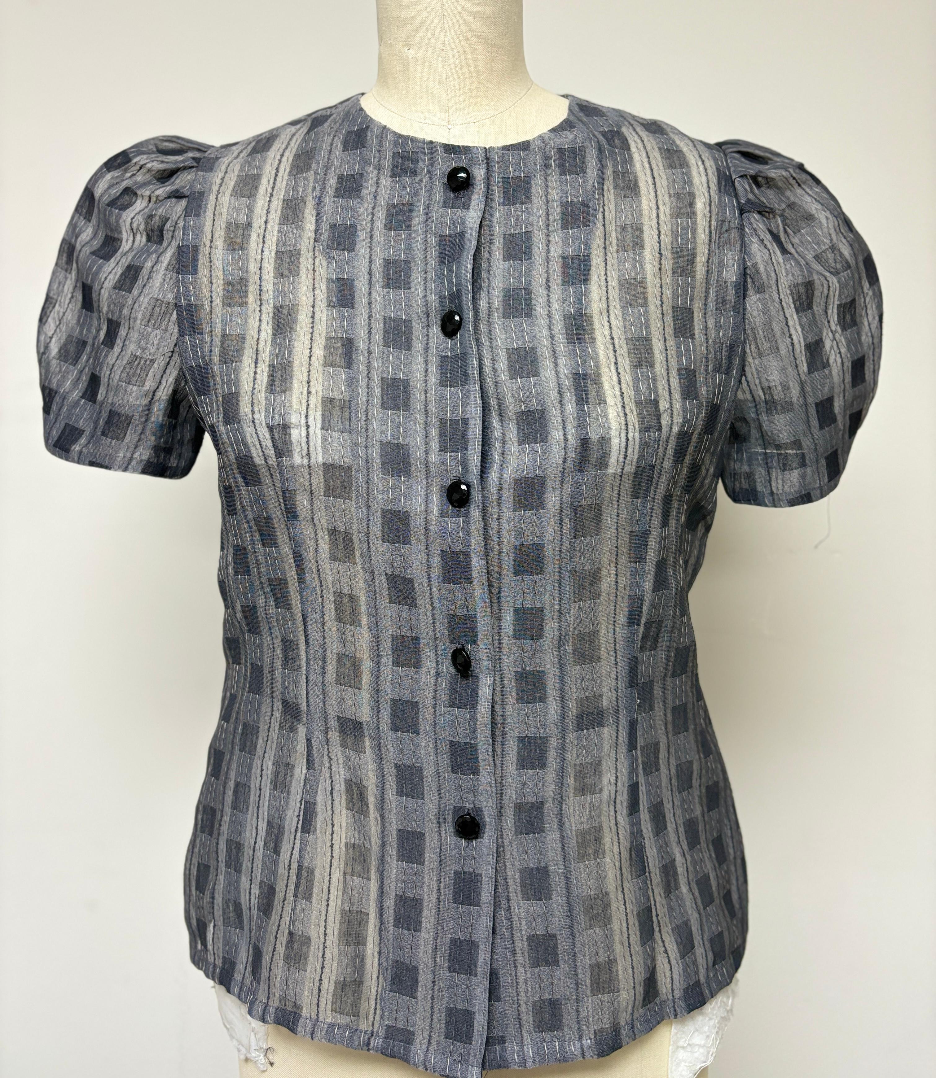 Truly unique fancy check pattern with lovely threadwork, creating a beautiful textile design for this blouse. Adorned with vintage black jet glass buttons on the front, this blouse pairs beautifully with a black skirt or pants. The puffy sleeves