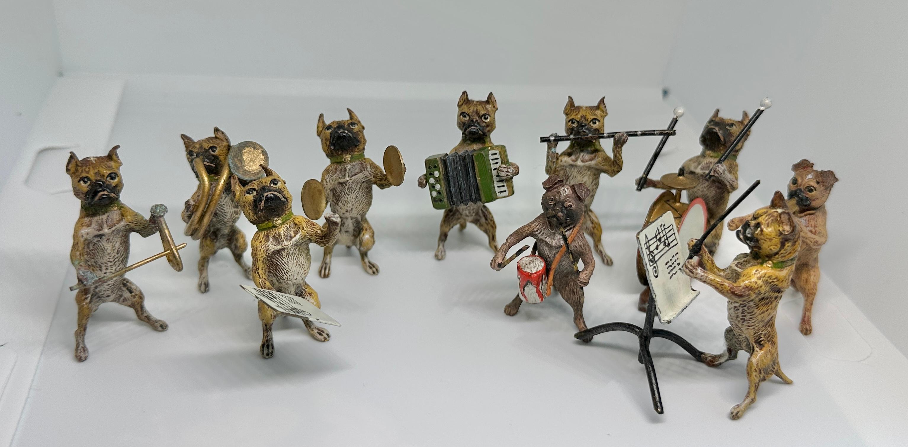 ESTA ES UNA RARA BANDA DE PERROS PUG BULLDOG CON DIEZ MÚSICOS Y DIRECTOR.  LOS PERROS MÚSICOS SON BRONCES AUSTRIACOS ANTIGUOS DE VIENA.  LA BANDA INCLUYE AL DIRECTOR CON ATRIL, UN CANTANTE CON MÚSICA, DOS TAMBORILEROS, TROMPETA, PLATILLOS, ACORDEÓN,