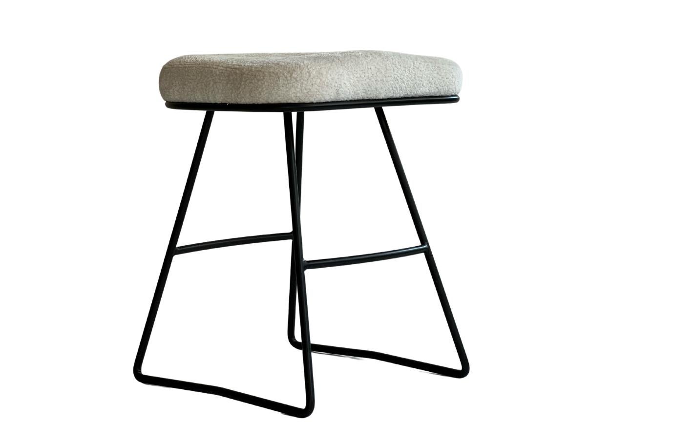 Der Mops ist ein Beistellhocker mit einem geformten gepolsterten Sitz und einem handgebogenen Metallgestell. Der Sitz ist von einem charakteristischen, handgebogenen Metallrahmen umgeben. Der ergonomisch geformte Holzsitz ist nicht nur schön,