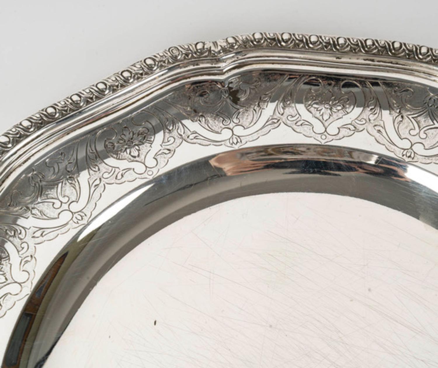 Plaque d'argent massif finement ciselée avec un décor Bérain et un décor ovale sur le bord.

Marque : MINERVE

Période : Vers 1880

Diamètre : 25 cm

Orfèvre : Emile Puiforcat

Origine : France : Paris