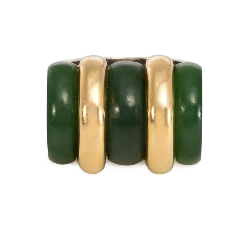 An Art Deco nephrite jade and gold ring with sterling silver shank.  Puiforcat, France.  The striking arrangement of barrel-shaped green nephrite jade combined with 18K yellow gold bands gives this unique statement ring a strong, sleek, and nearly