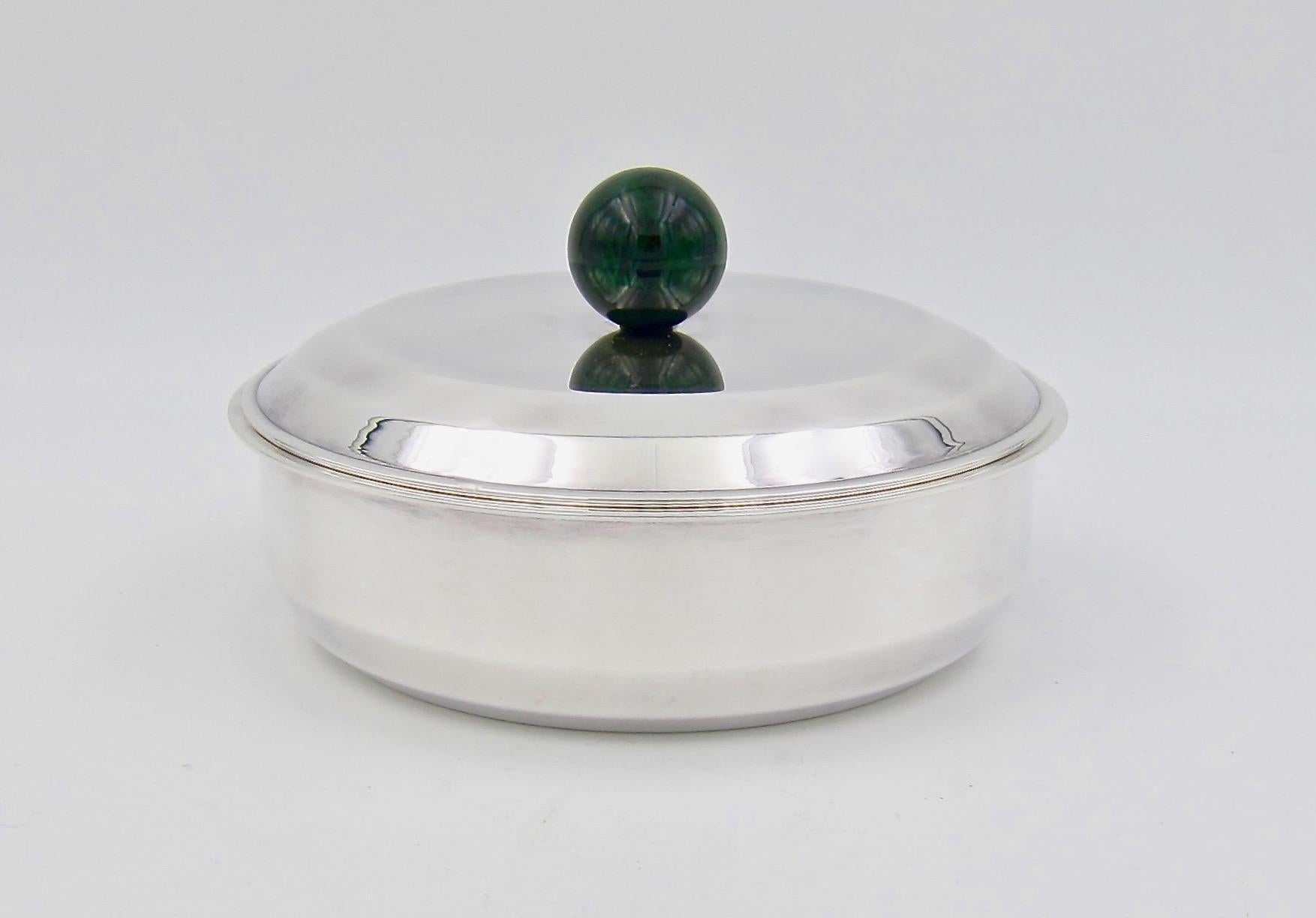 A French Art Deco bonbonnière or vanity box designed by Jean-Emile Puiforcat (1897-1945) in silver-plate with a spherical finial in veined dark green enamel, dating circa 1930s. The elegant circular covered box is an ideal accessory for a vanity,