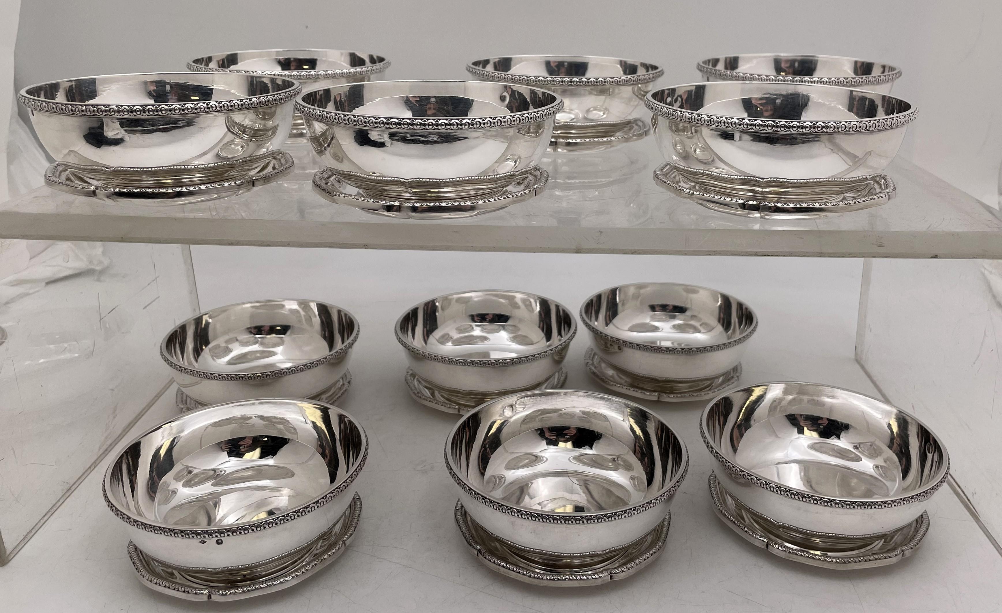 Puiforcat, French 0.950 (higher purity than sterling) silver set of 12 dessert / compote bowls with 12 matching underplates, with a beautiful, curvilinear design, and rims adorned with stylized geometric motifs. The bowls measure 4 1/4'' in diameter
