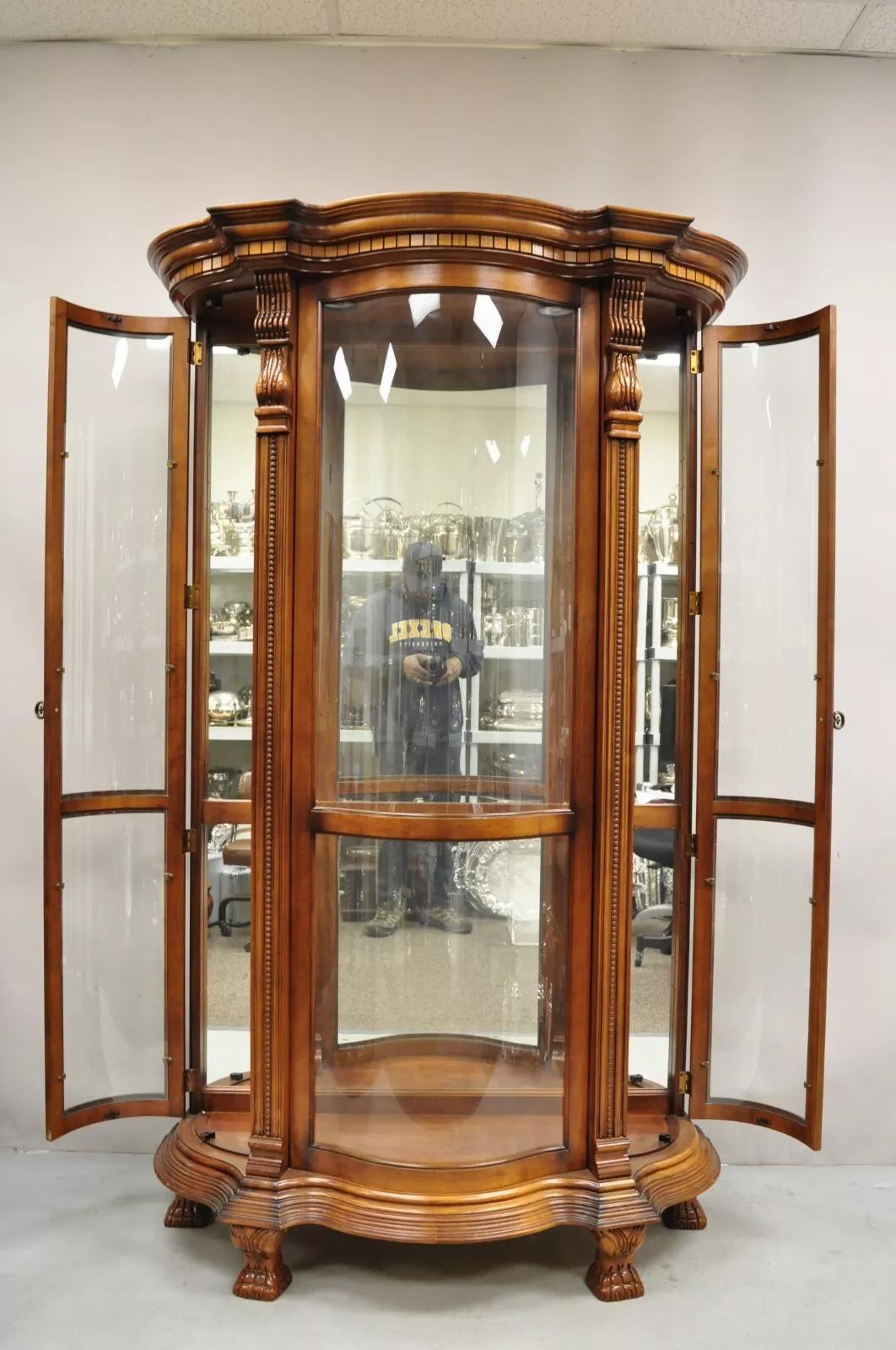 Pulaski Empire Style Cherry Wood Large Bowed Glass Illuminated Curio Display Cabinet. Item features 2 side entry doors, carved paw feet, large impressive size, curved glass panes, lighted interior, mirror back, quality American craftsmanship.