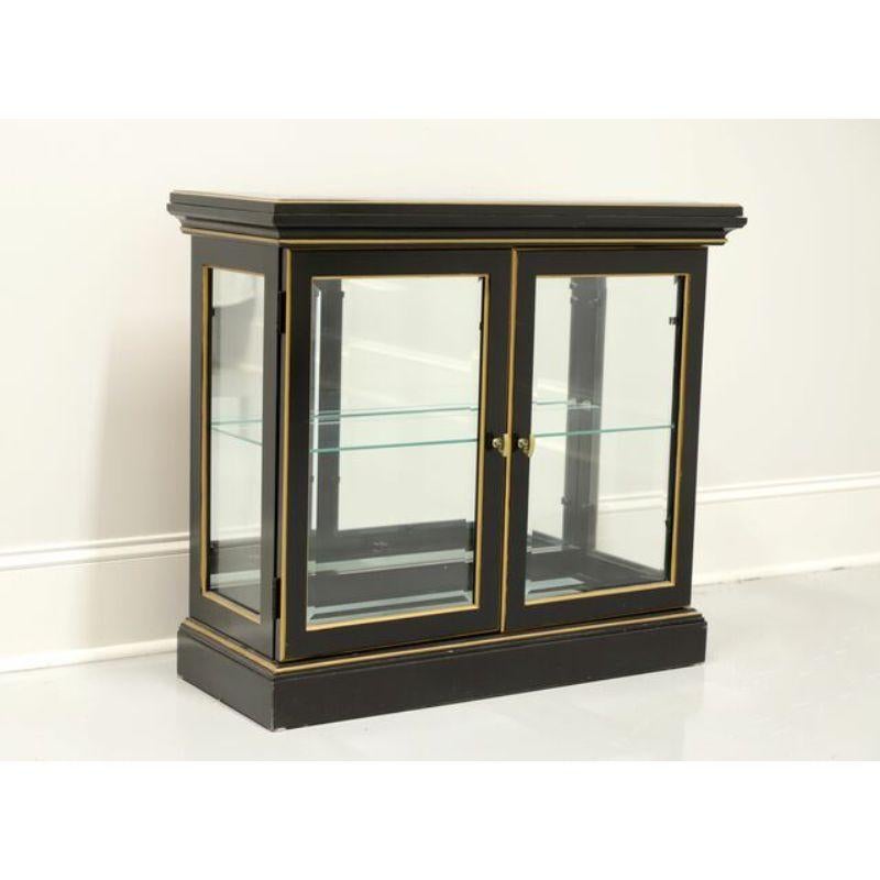 An Asian style display console cabinet by Pulaski Furniture. Black lacquered solid wood, gold accents, brass hardware and glass dual front doors, side panels, top. Features mirrored back, floor lighting and one adjustable plate grooved glass shelf.