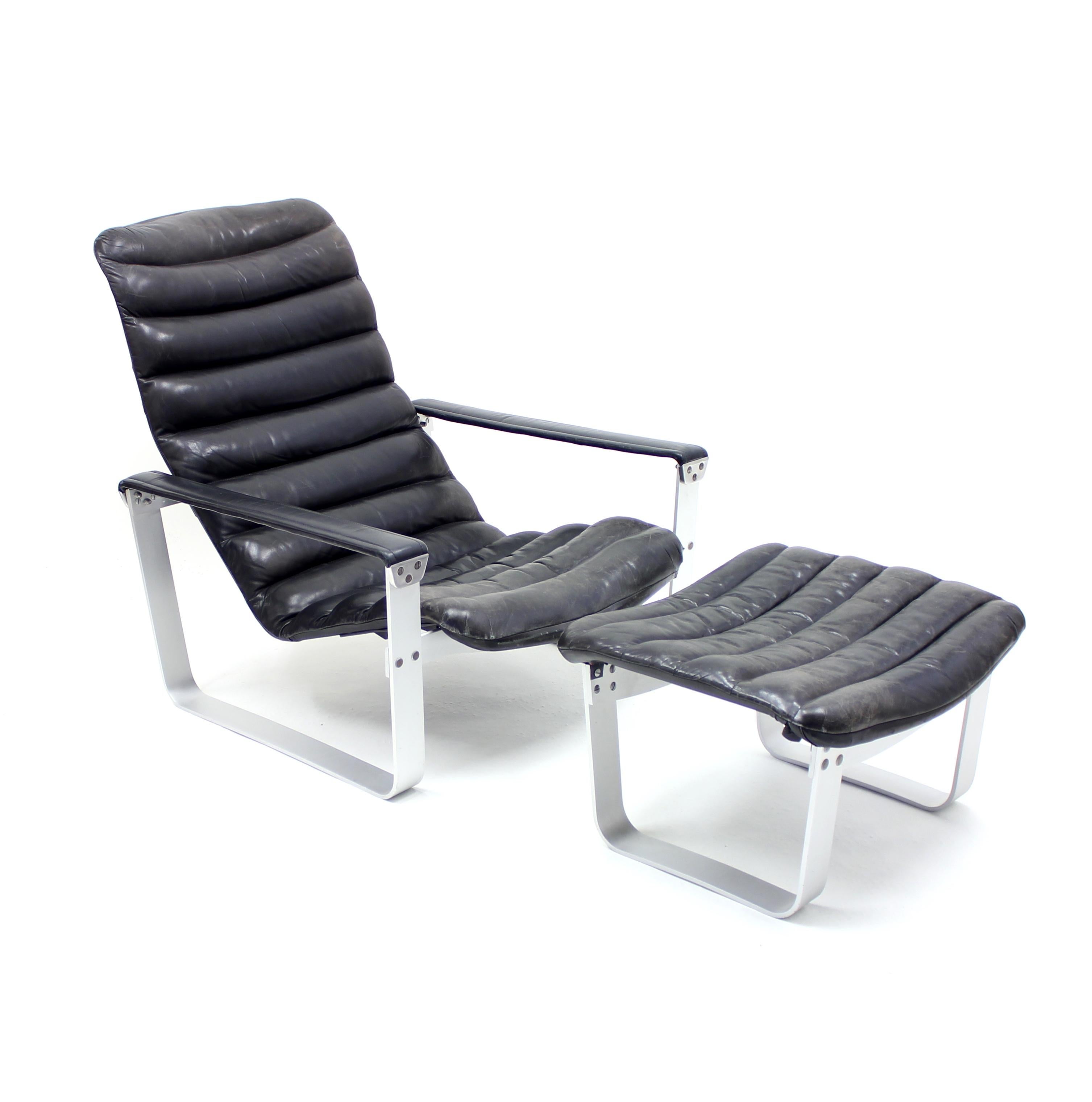 Adjustable lounge chair, model Pulkka, by Ilmari Lappalainen for ASKO with ottoman in original black leather and aluminium. Designed in 1968. The seat can be adjusted in three different positions. Faded ASKO sticker under ottoman. Very good vintage