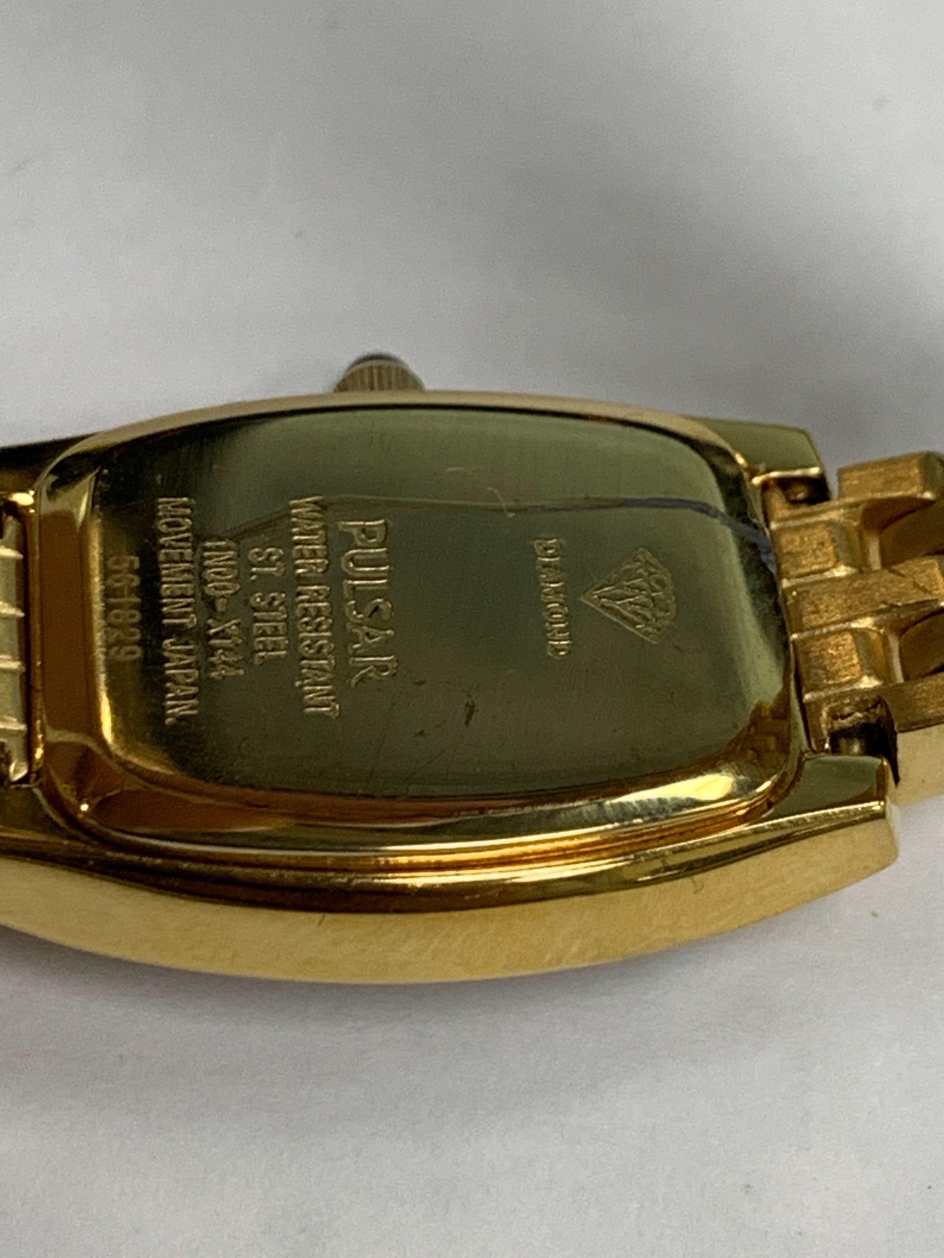 Dieser gebrauchte Pulsar  1N00-X124 ist eine schöne Damenuhr, die von einem Quarzwerk (Batterie) angetrieben wird und in einem Edelstahlgehäuse untergebracht ist. Es hat eine ovale Form Gesicht, keine Funktionen Zifferblatt und hat Hand Sticks &