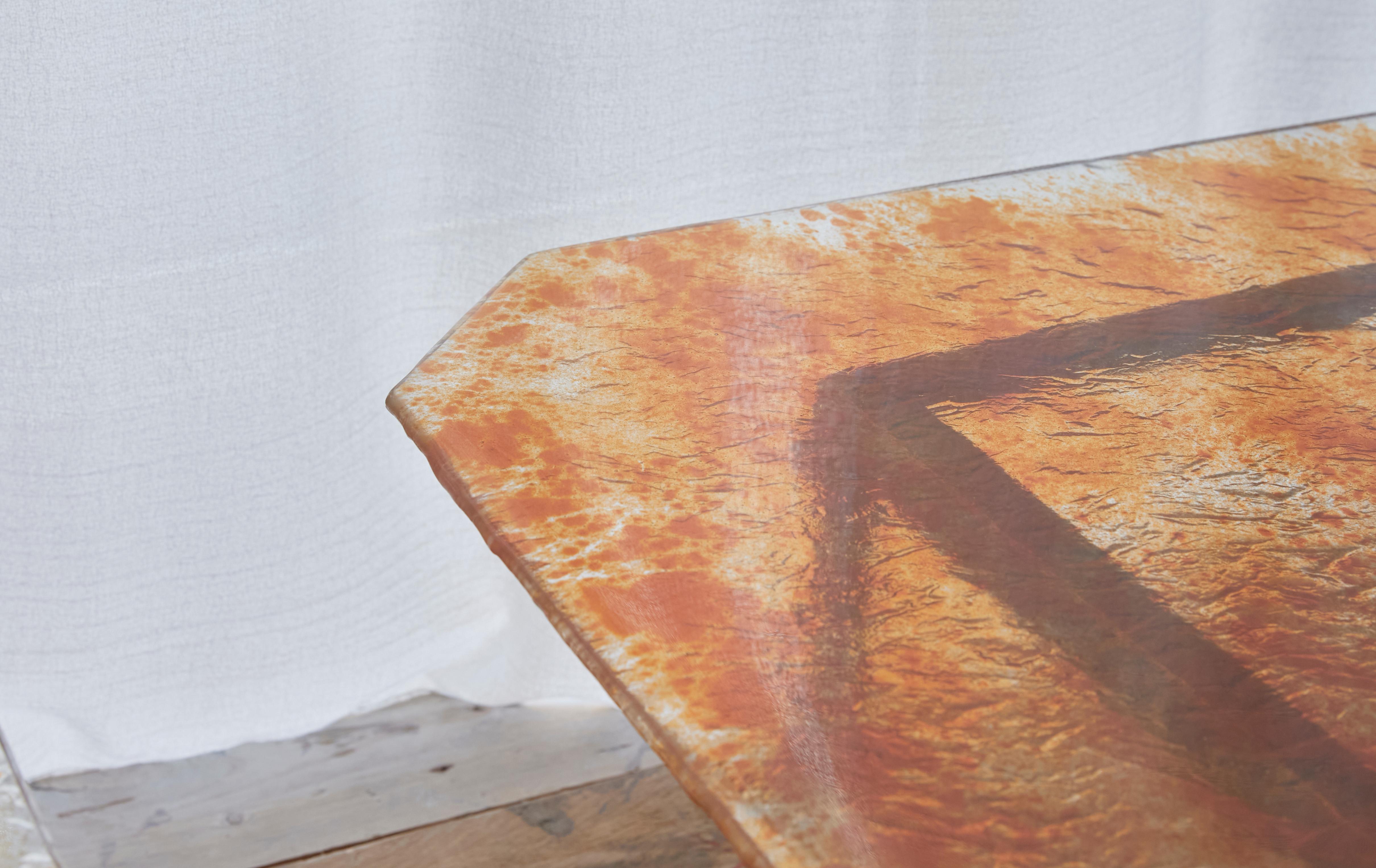 Low sculptural table with hand-carved bronze structure by spanish artist José Onieva and 6mm handmade glass, with pigment melted at high temperature to achieve this distortion of color and irregular texture  when in contact with the glass. The