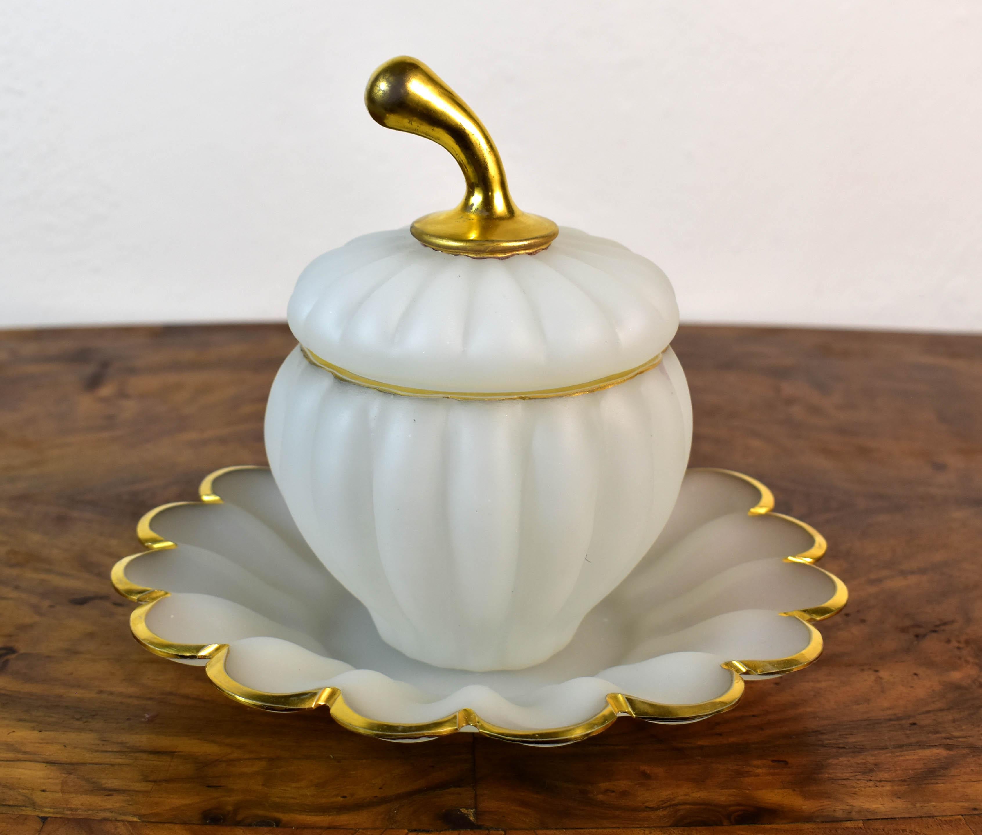 A beautiful and very interesting jar with a plate made of opaline glass. The pumpkin-shaped jar is made of white opaline with a gold chip, and the plate is also complemented by a gold painting. It is an interesting and unusual shape, just like the