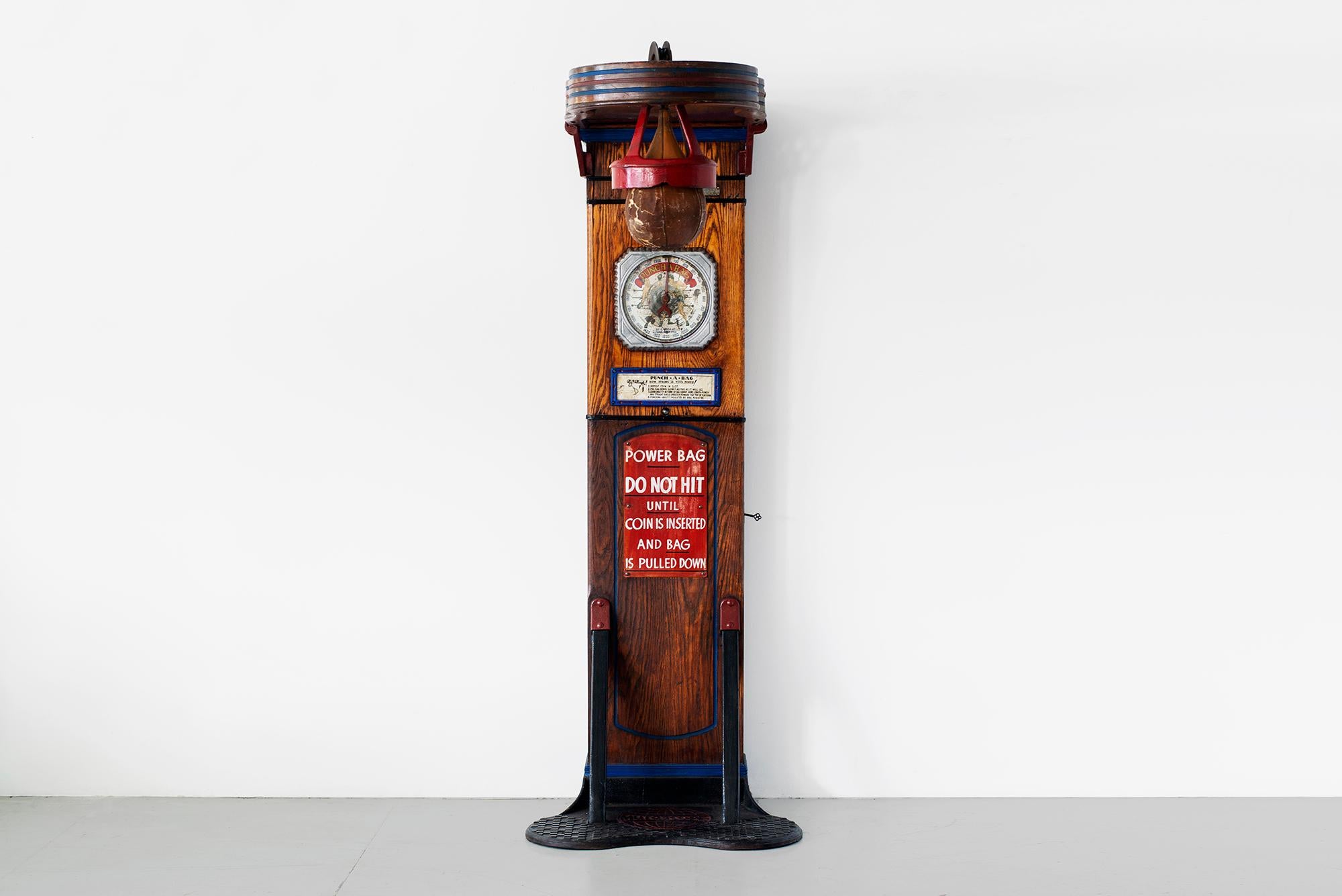 This rare 1920s coin-op punching game, manufactured by Mutoscope is designed to measure the strength of one's punch. Fully restored and in working condition - the game features a leather punching bag suspended from an upper platform. Wonderful