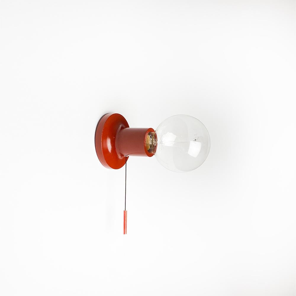 Punt wall or ceiling sconce design by Jordi Veciana and Skye Maunsell for Carpyen.

Manufactured in cast aluminium. Terracotta colour.

Version with switch.

E27 bulb. Max 100w.

Measurements: 10x8 cm.