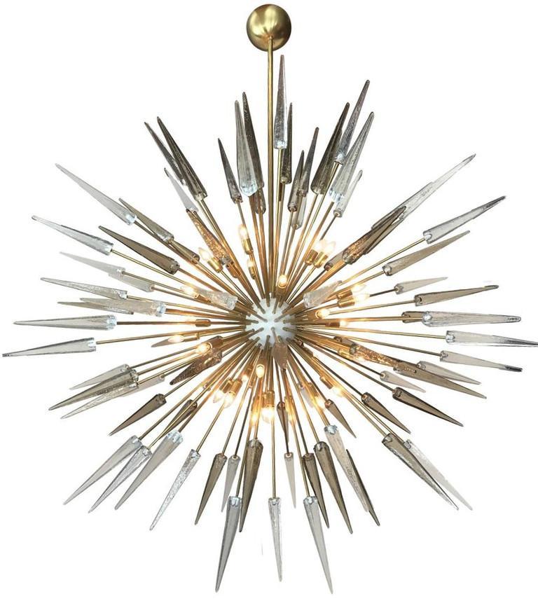 Lampadario italiano moderno a sputnik con punte in vetro di Murano chiaro e fumé, montato su una struttura in ottone naturale non laccato con centro smaltato bianco, disegnato da Fabio Bergomi per Fabio Ltd / Made in Italy
30 luci / tipo E12 o E14 /