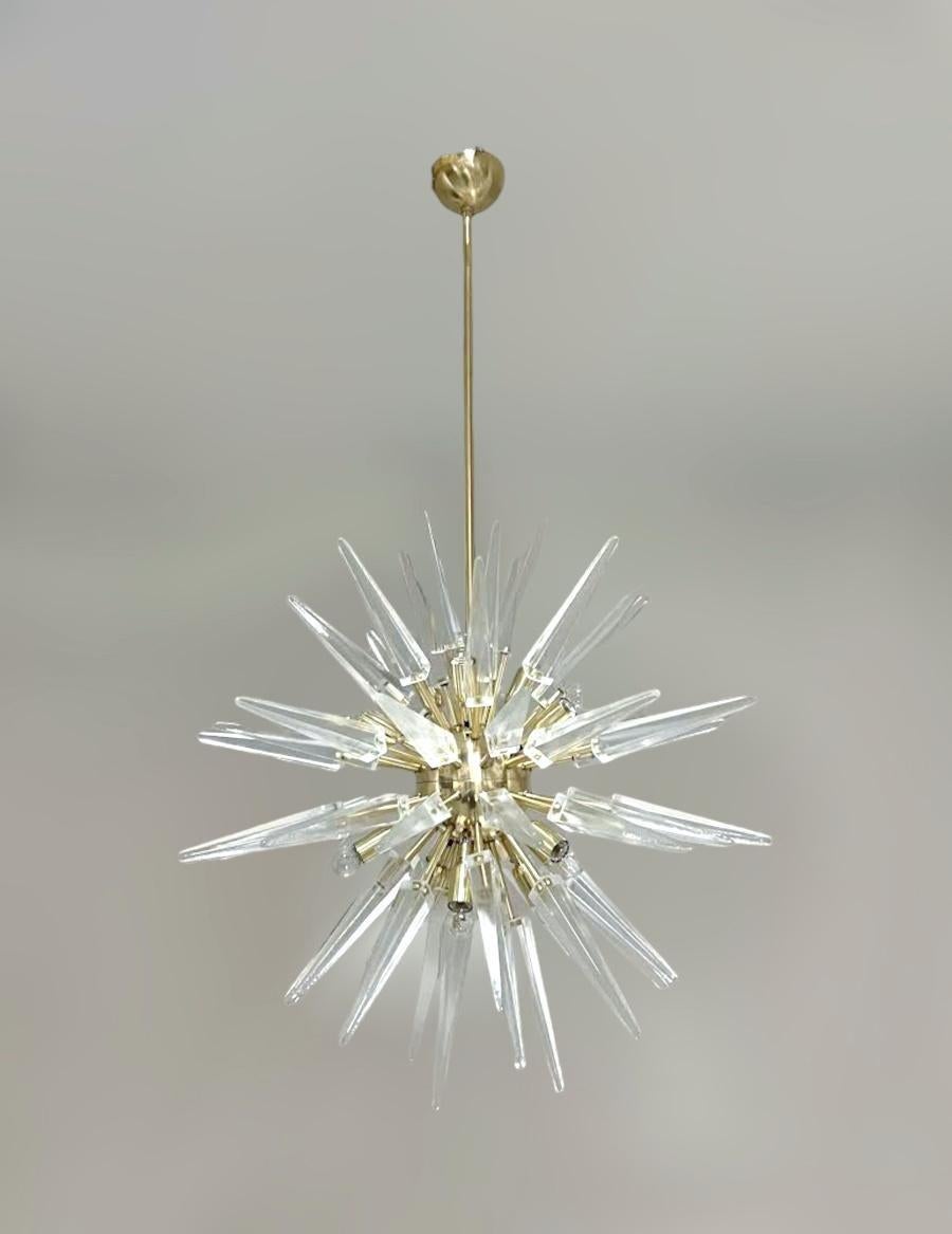 Lampadario italiano moderno Sputnik con punte di frammenti di vetro di Murano trasparente, montato su una struttura in ottone naturale non laccato, disegnato da Fabio Bergomi per Fabio Ltd / Made in Italy
12 luci / tipo E12 o E14 / max 40W