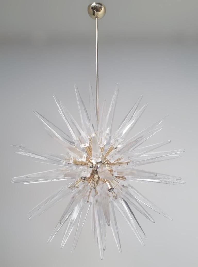 Lampadario sputnik moderno italiano con punte in vetro di Murano trasparente, montato su una struttura in ottone massiccio con finitura lucida, disegnato da Fabio Bergomi per Fabio Ltd / Made in Italy
12 luci / tipo E12 o E14 / max 40W