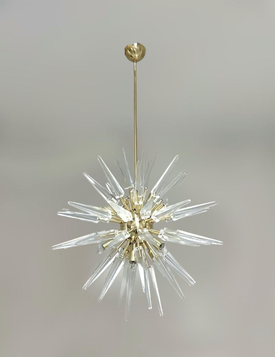 Italian modern sputnik chandelier with clear Murano glass shards spikes, mounted on natural unlacquered brass frame, designed by Fabio Bergomi for Fabio Ltd / Made in Italy
12 lights / E12 or E14 type / max 40W each
Measures: diameter 30 inches,