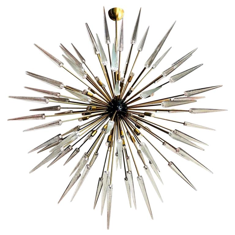 Italian modern Sputnik chandelier with clear Murano glass shards spikes, mounted on natural unlacquered brass frame with black enameled centre, designed by Fabio Bergomi for Fabio Ltd, made in Italy
30-light / E12 or E14 type / max 40W