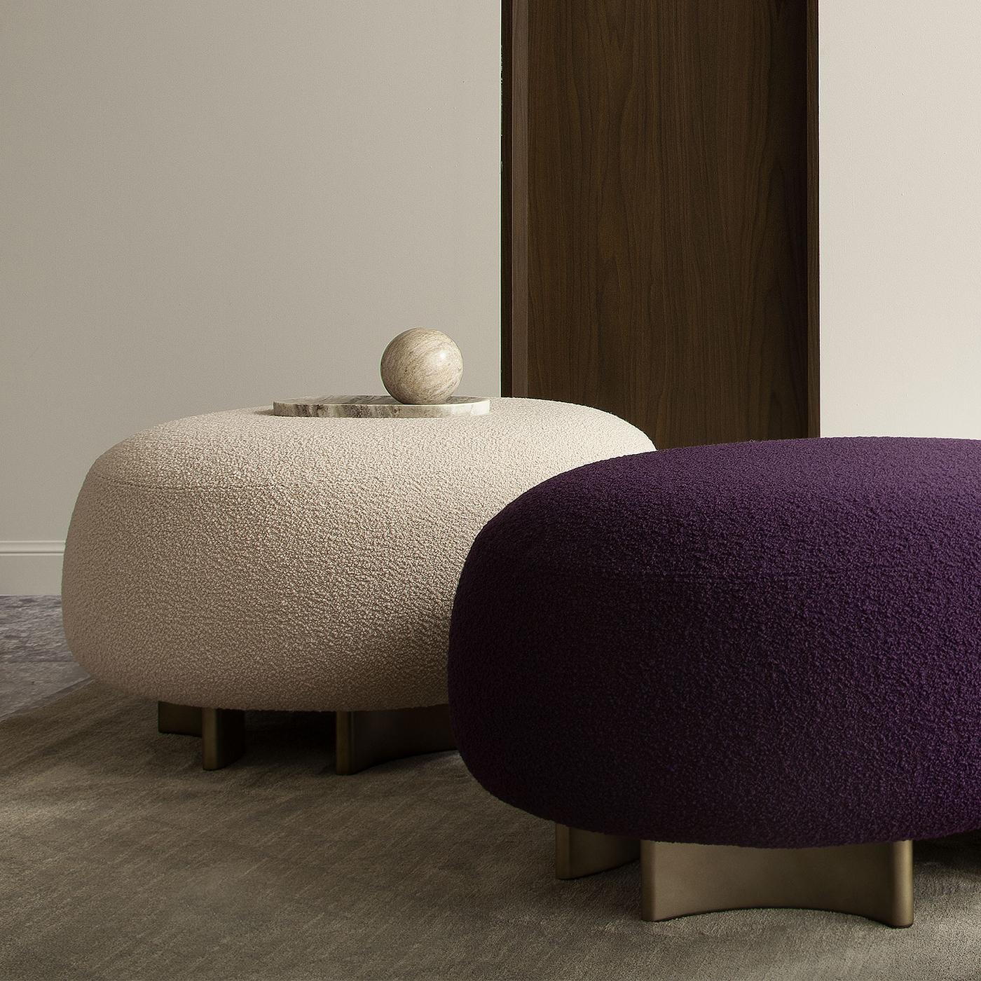 Crafted with meticulous attention to detail, this pouf features a high-density foam seat upholstered in a powder pink bouclé fabric, combining comfort with a touch of elegance. The fully removable cover allows for easy maintenance, while the curved