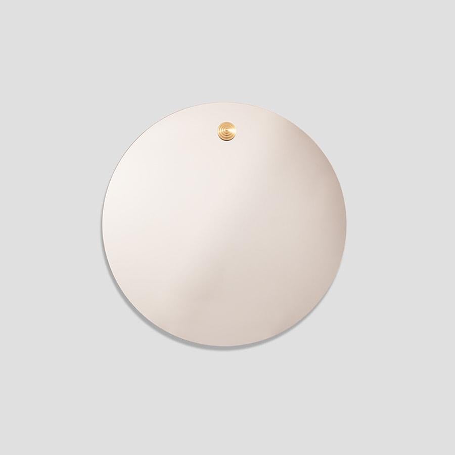 Pupila takes its name from the pupil, the eye’s quiet center, where focus begins and meaning takes shape.

Circular and striking in its restraint, the piece is crafted from warm bronze mirror, casting a soft, dimensional glow that shifts with the