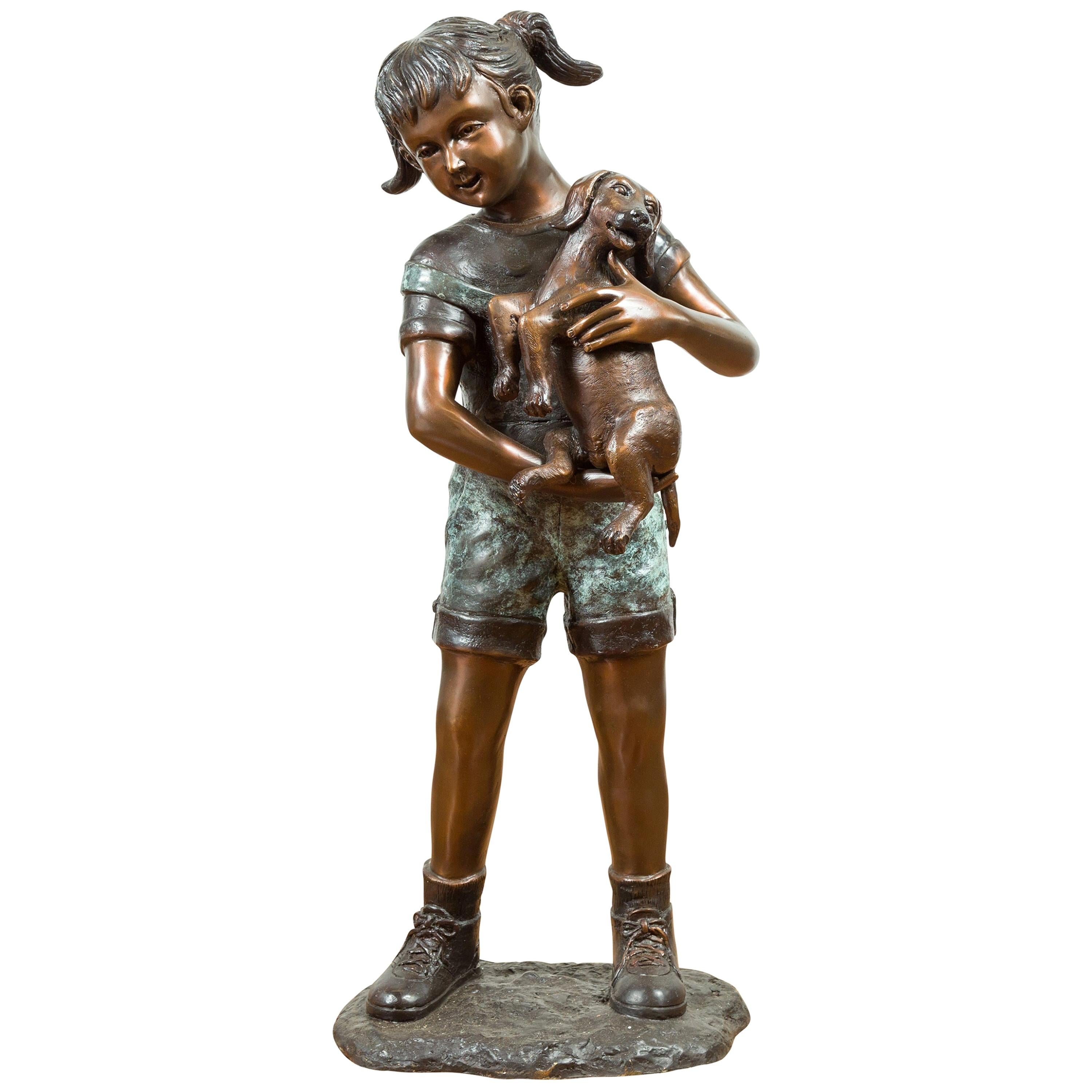 Statue contemporaine en bronze coulé d'une petite fille tenant son chiot, Puppy Kisses