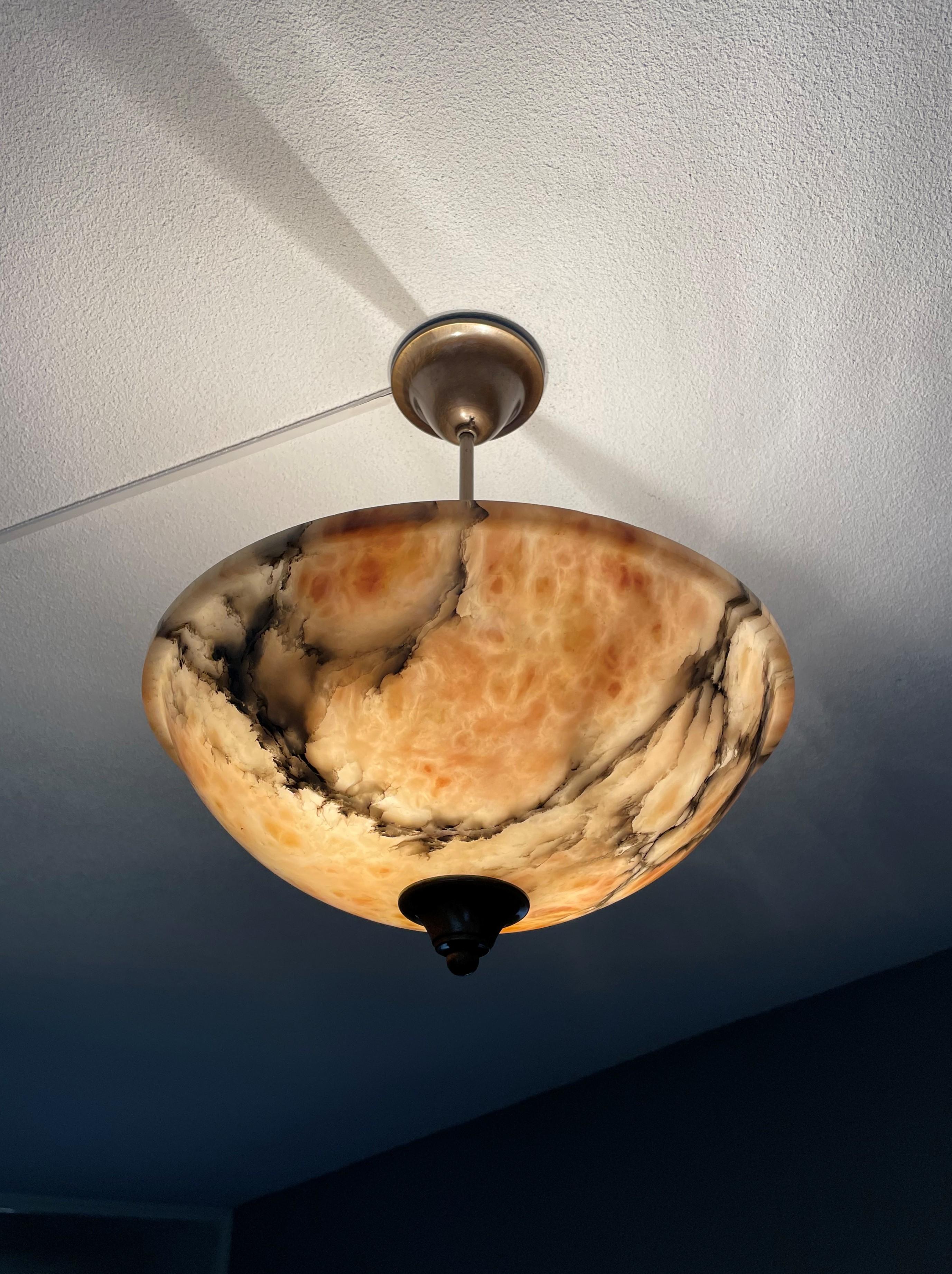 Unique and good size, two-light alabaster ceiling lamp of superb quality and condition.

This light fixture from the heydays of the European Art Deco era will light up both your days and evenings. Its timeless shade is all hand carved out of one