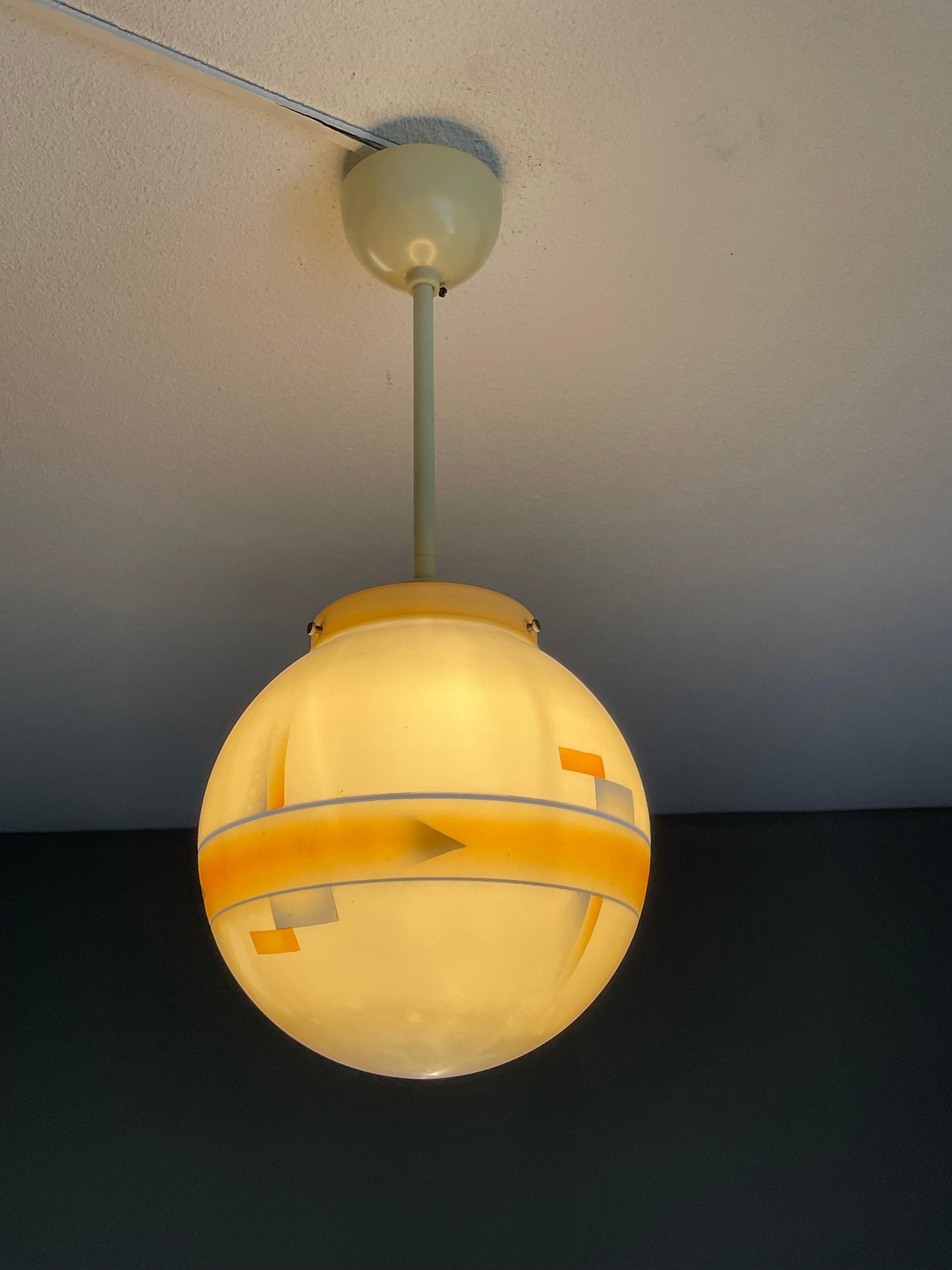Handcrafted glass globe Art Deco pendant with colored geometrical patterns.

This rare combination of materials Art Deco pendant or flush mount is in excellent condition and a real joy to own and look at. This quality crafted antique light fixture