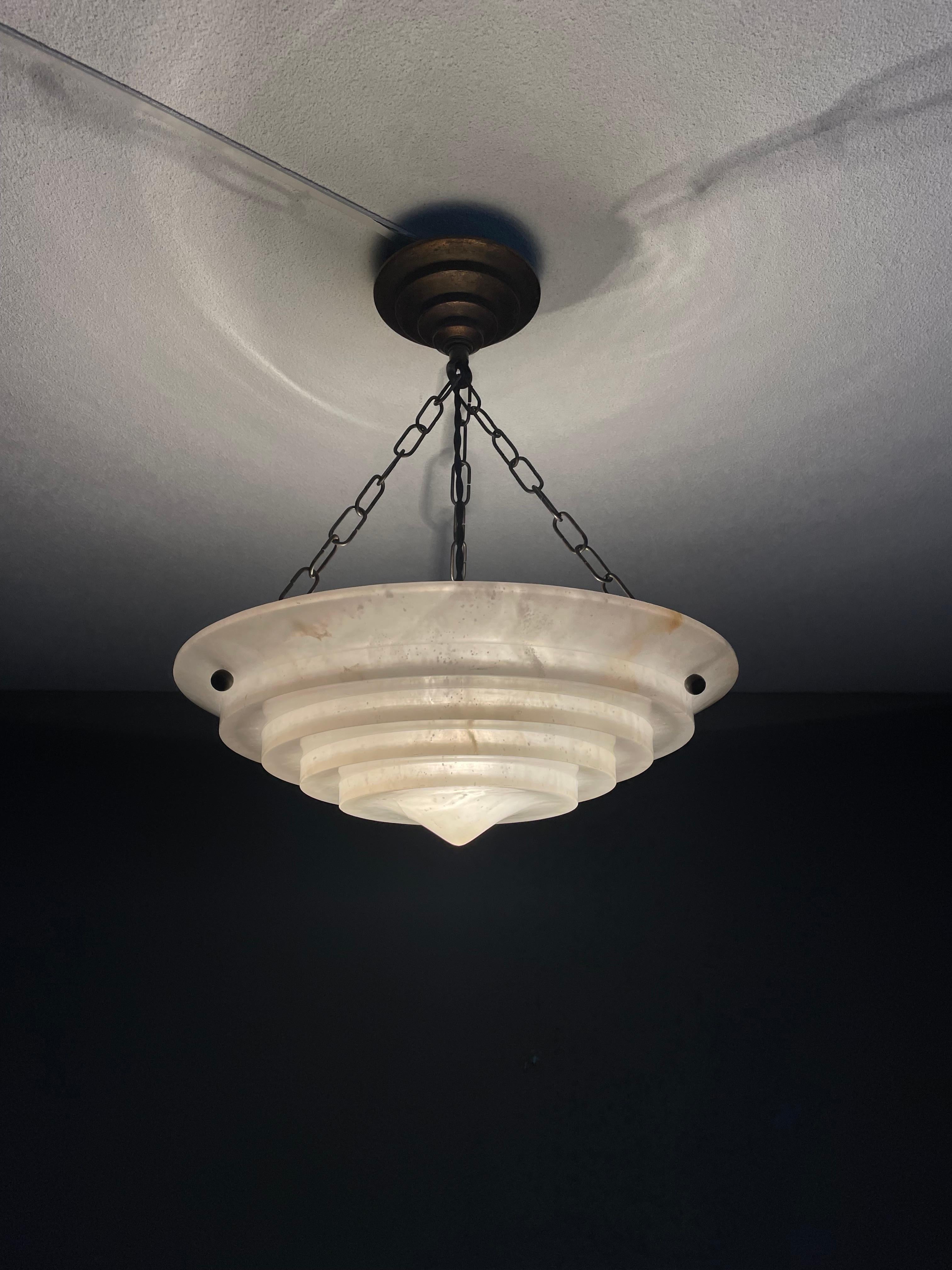 Stunning and good size, alabaster pendant of great quality and good condition.

This rare fixture from the heydays of the European Art Deco era could soon be lighting up your days and evenings. Its remarkable, circular and layered shade is all