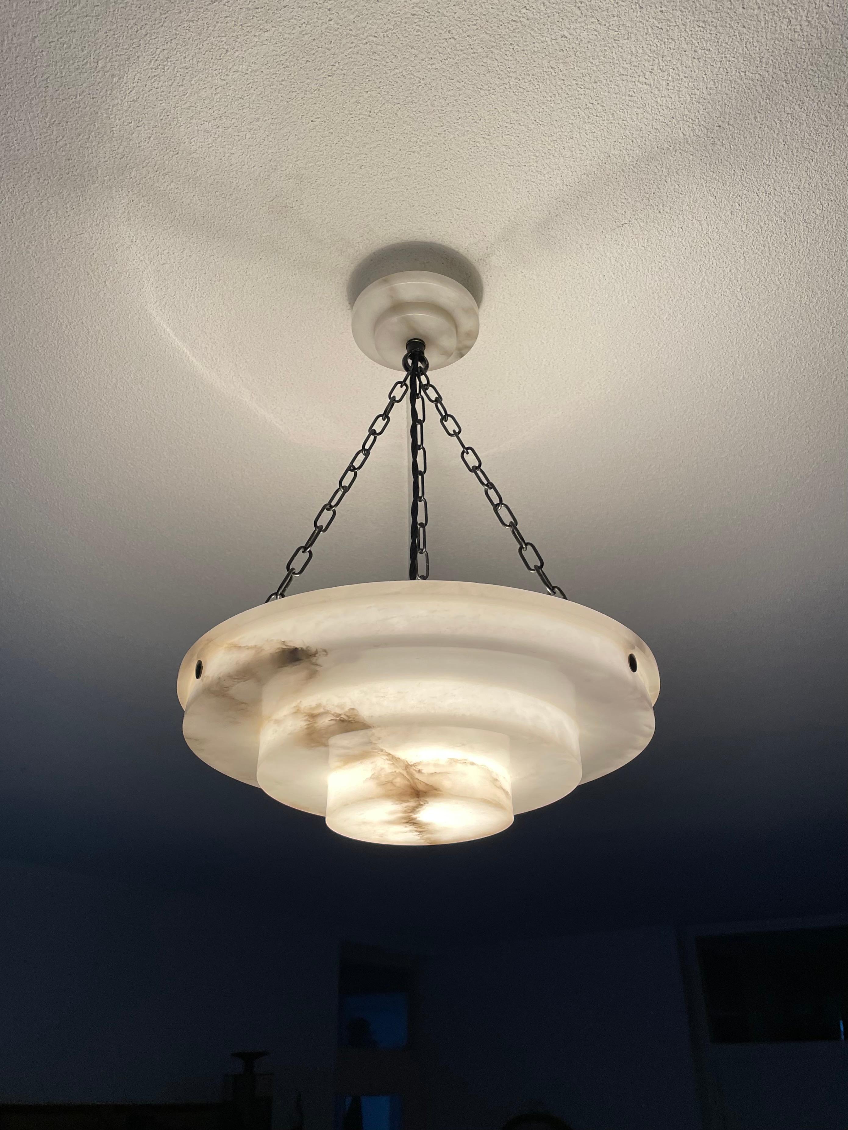 Stunning and practical size, alabaster pendant of great quality and superb condition.

This rare fixture from the heydays of the European Art Deco era will light up both your days and evenings. Its remarkable, circular and layered shade is all