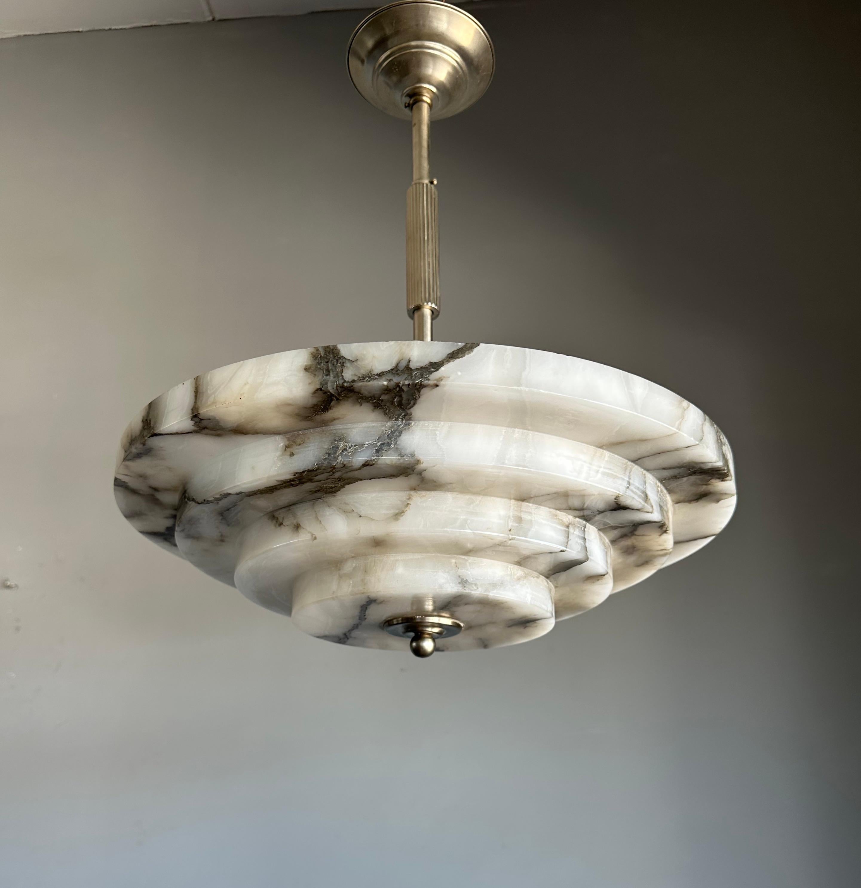 Stunning and large alabaster pendant of great quality and superb condition.

This rare fixture from the heydays of the European Art Deco era will light up both your days and evenings. Its remarkable, circular and layered shade is all hand carved out