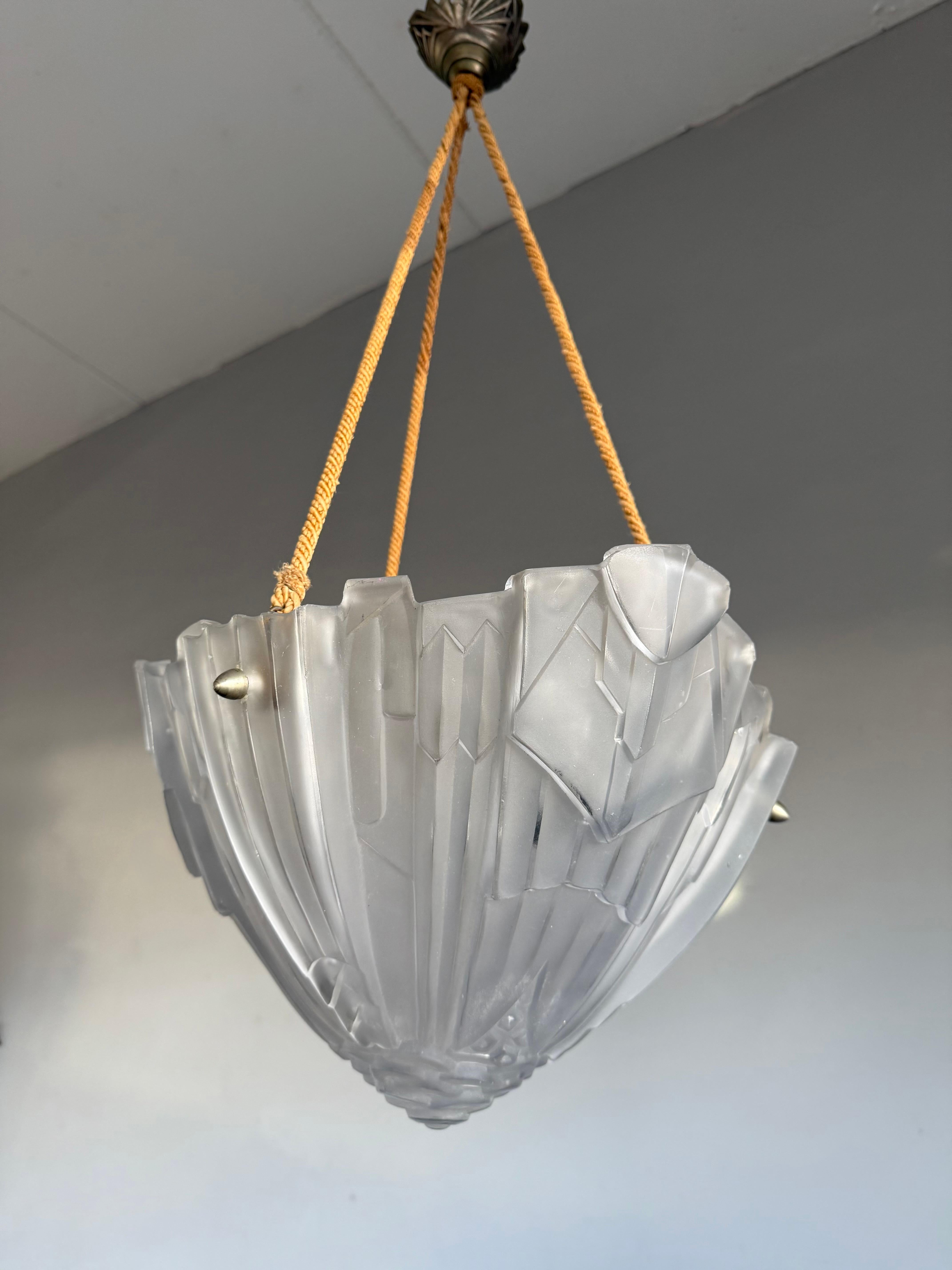 Une autre lampe suspendue française ancienne de qualité supérieure avec un design Art Deco parfait.

Ce superbe plafonnier Art déco de qualité supérieure a été réalisé par le verrier Léon Auguste Hugue (Paris, 1878 - Clichy-la-Garenne, 1970) qui a