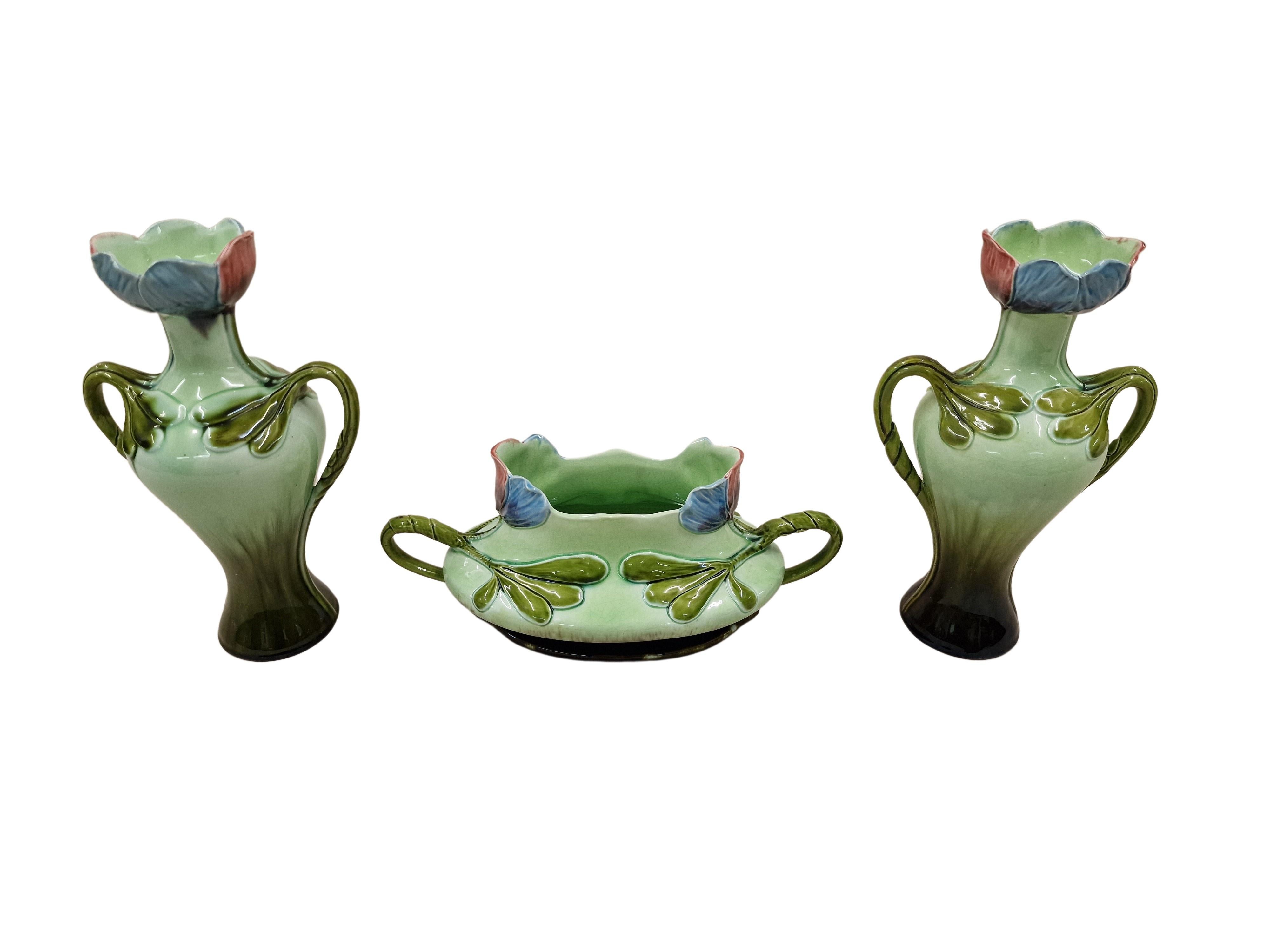Wonderful trilogy of flowers, consisting of two vases and a jardiniere. Manufactured by the famous ceramics workshop Julius Dressler in pure floral Art Nouveau.

The three objects have the same design, they all have two handles and the same