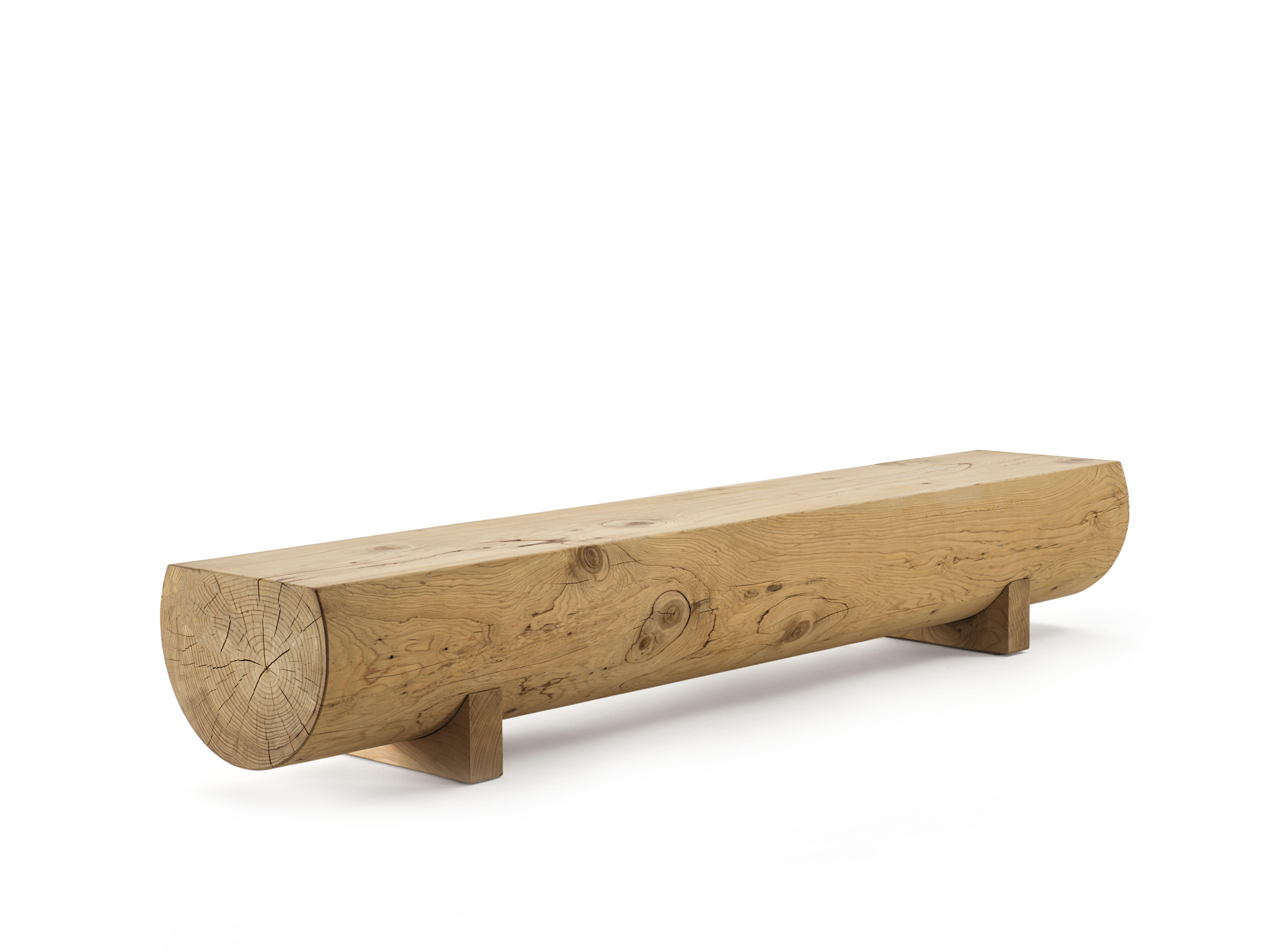 Bench made from a single block of scented cedar. Distinguished by its minimalist and extremely natural design. Rests on feet made from the same wood.