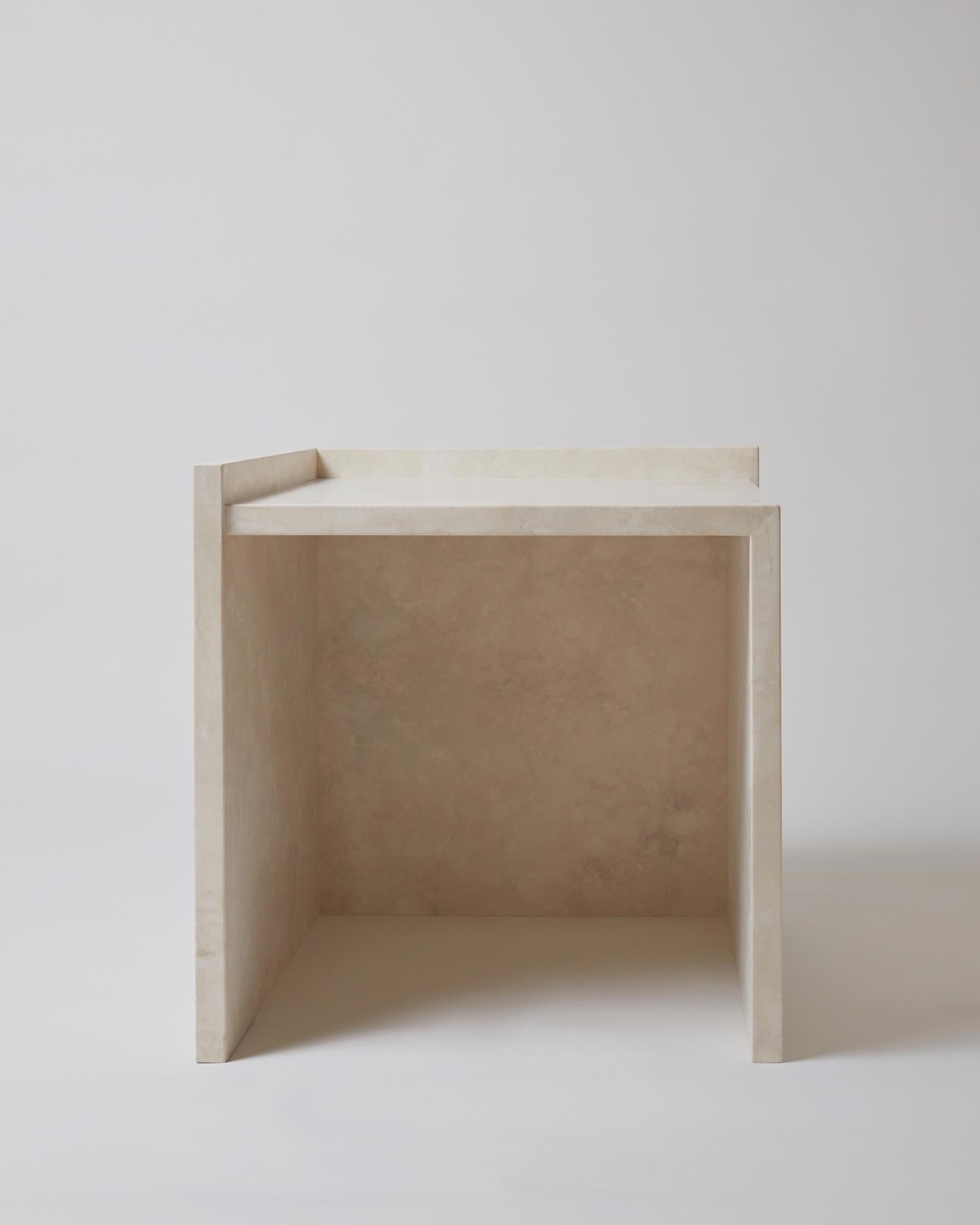 The AA112.1 side table, part of the 'Pure Minimalist' collection by Amee Allsop, is a simple yet architectural design with a focus on the material and form. It is elegantly constructed of 3cm solid ivory travertine that is filled, honed and
