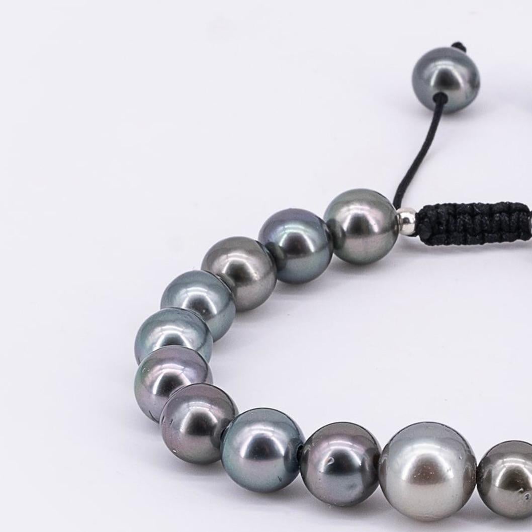 A classic yet modern way for Men to wear pearls. This bracelet is made of beautiful gray hued Tahiti pearls in an A+ -AA quality. 
The average diameter is 10mm in size. The bracelet can be closed with a black drawstring closure that makes it easy to