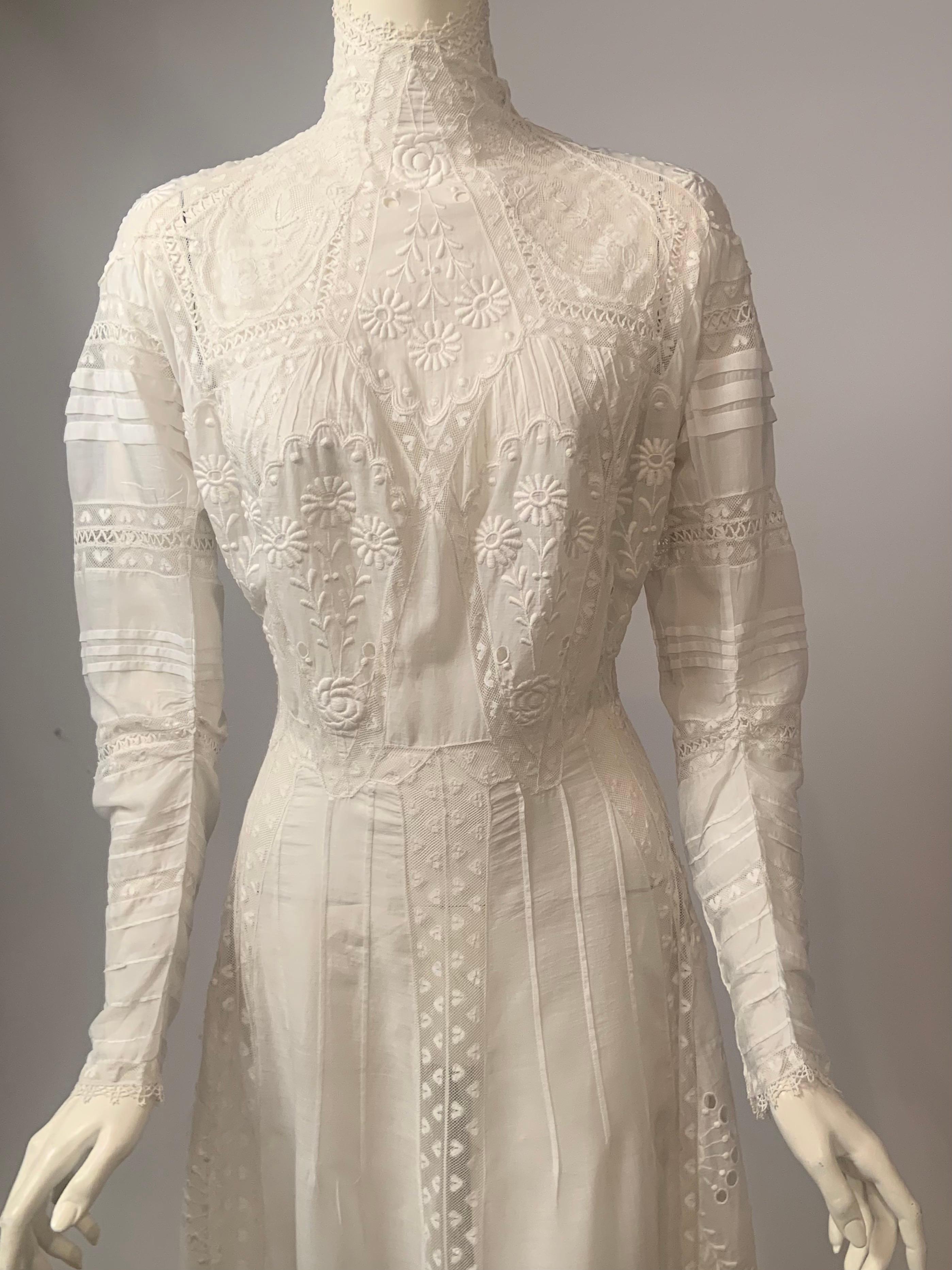 Cette robe victorienne a tout pour plaire !  Réalisée dans un lin mouchoir très fin, elle présente un col montant, une broderie florale exquise, une quantité très généreuse d'insertions de dentelle à motif de cœur, ainsi que des découpes, des pinces