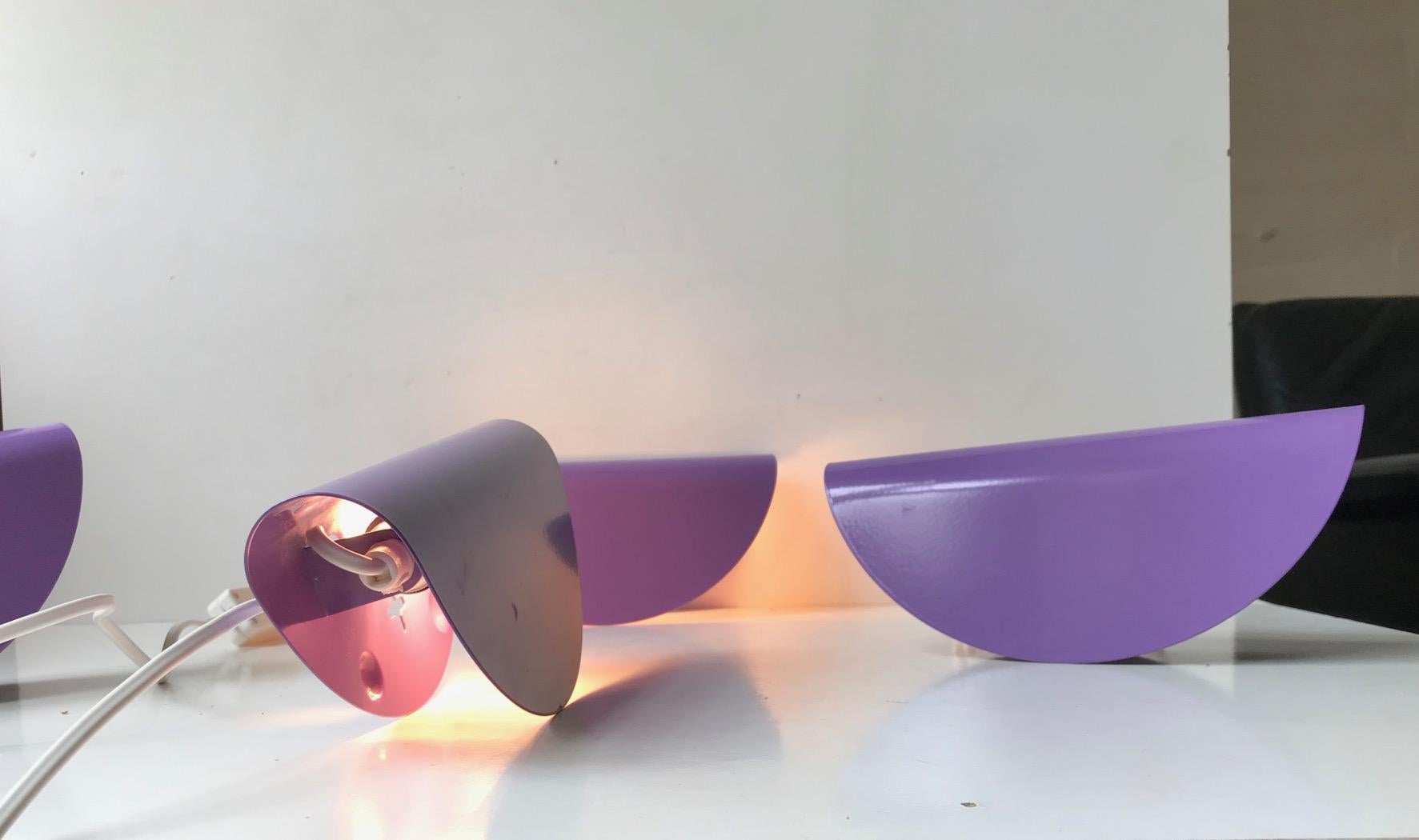 Matching set of 4 purple wall lights. Stylistically they are in the realm of Nordic/Scandinavian Minimalism. Designed and manufactured in Denmark during the 1980s or early 1990s. They are made from a circle of powder coated steel that are bend so