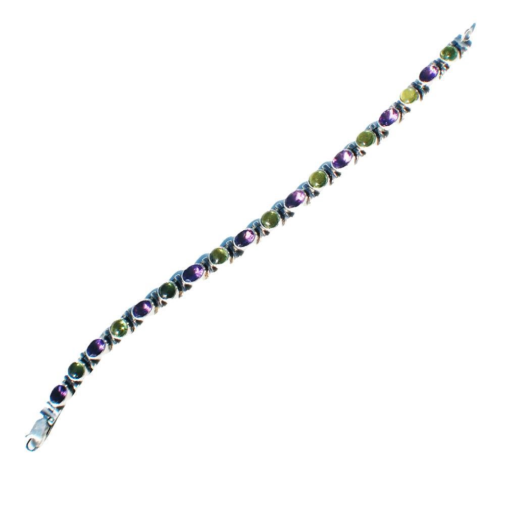 Alternating cabochon stones in saturated colors of green and purple
Amethyst are set in a link bracelet.  
The sturdy setting bezel sets the colored stone so they have a nice glare in sunlight. A security latch is on either side of a sturdy clasp