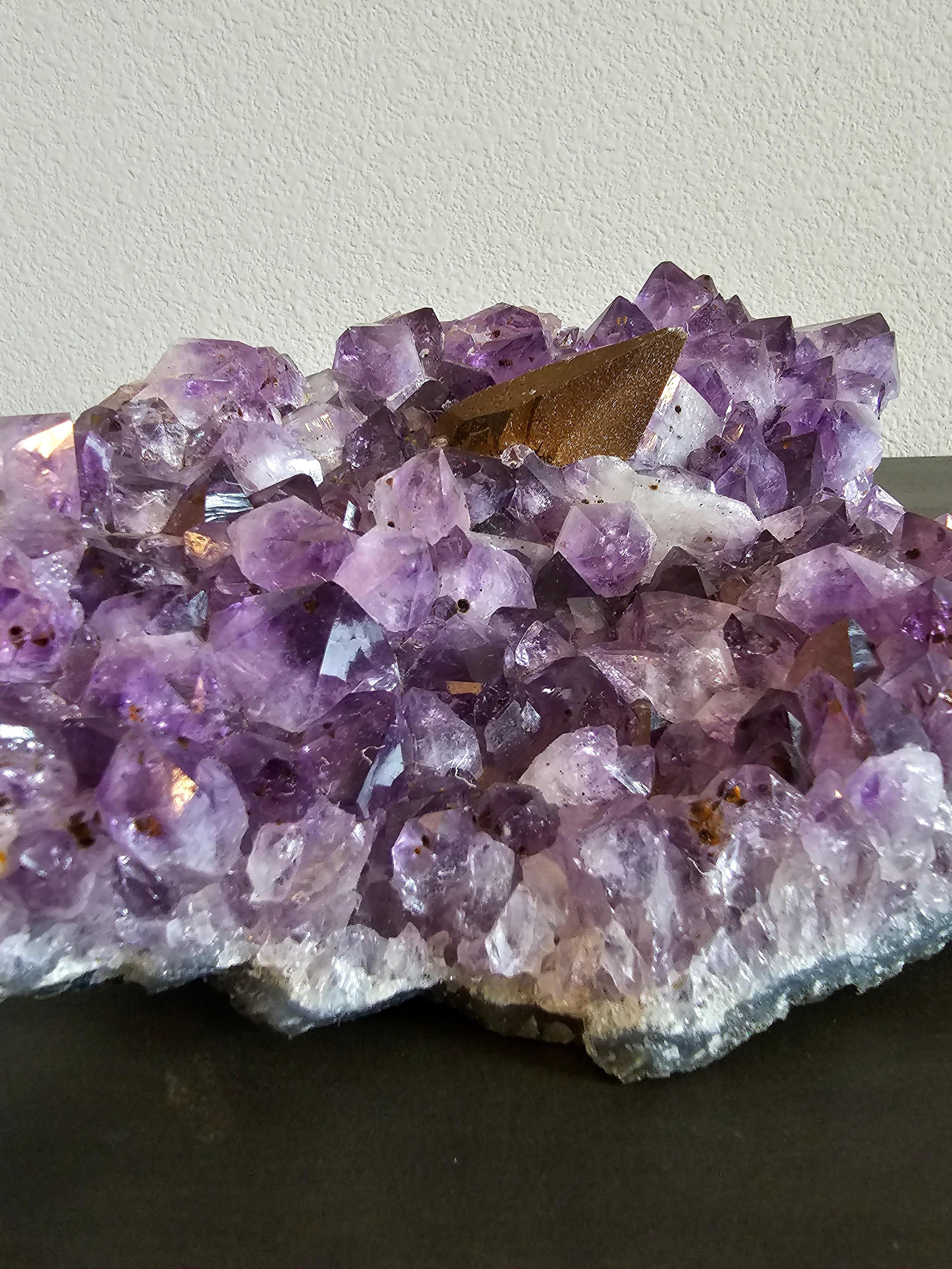 A large brilliant natural amethyst specimen that displays large crystal terminations, rich inclusions and calcite formations throughout, and a single large hematite spike.

Dimensions: (approx)
11.5