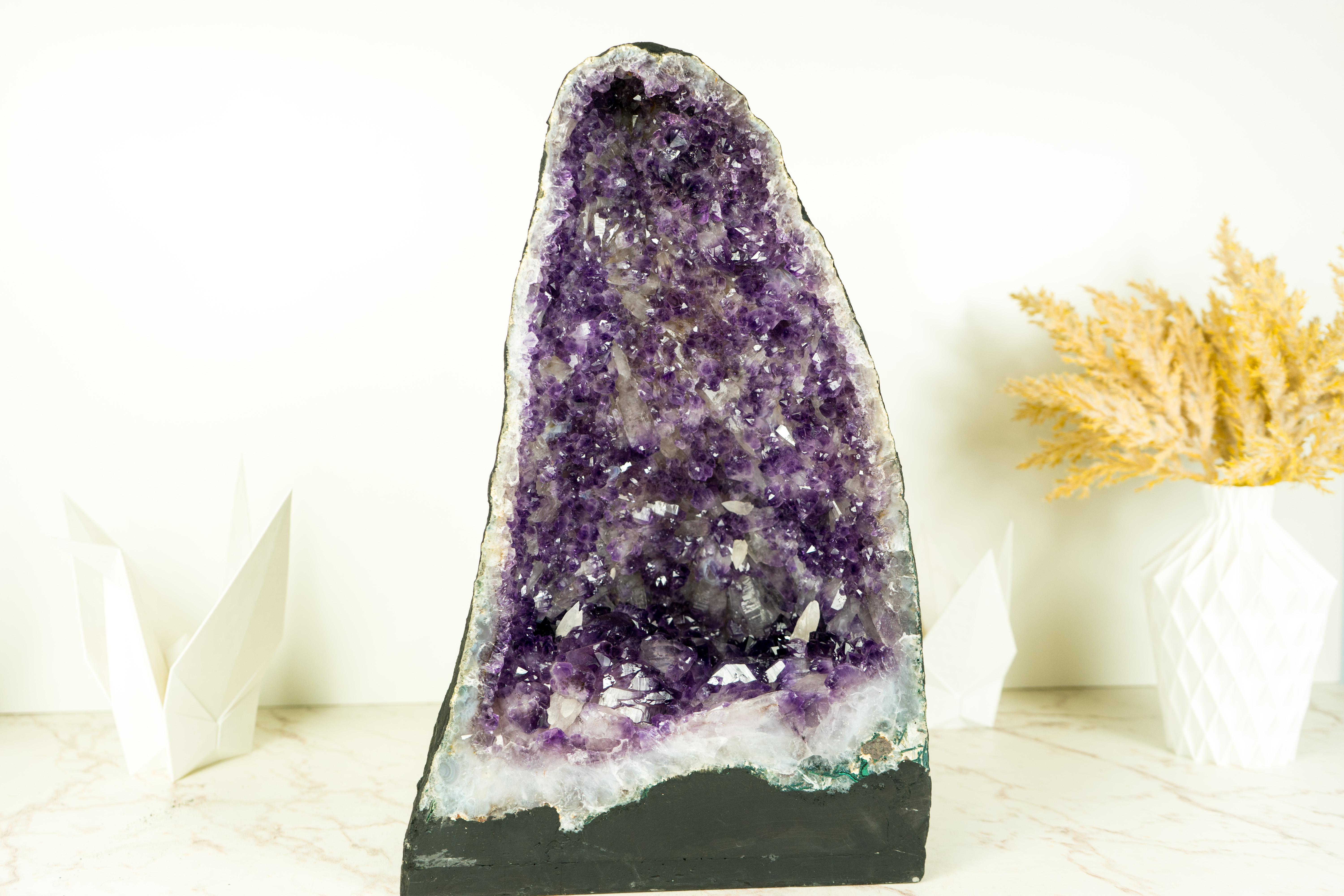 An Amethyst Geode that brings rarely seen dual-zoned purple Amethyst druzy, gorgeous aesthetics, and rare calcite inclusions, this is a piece of natural artistry. This geode is a centerpiece that will elevate your home or office decor to another