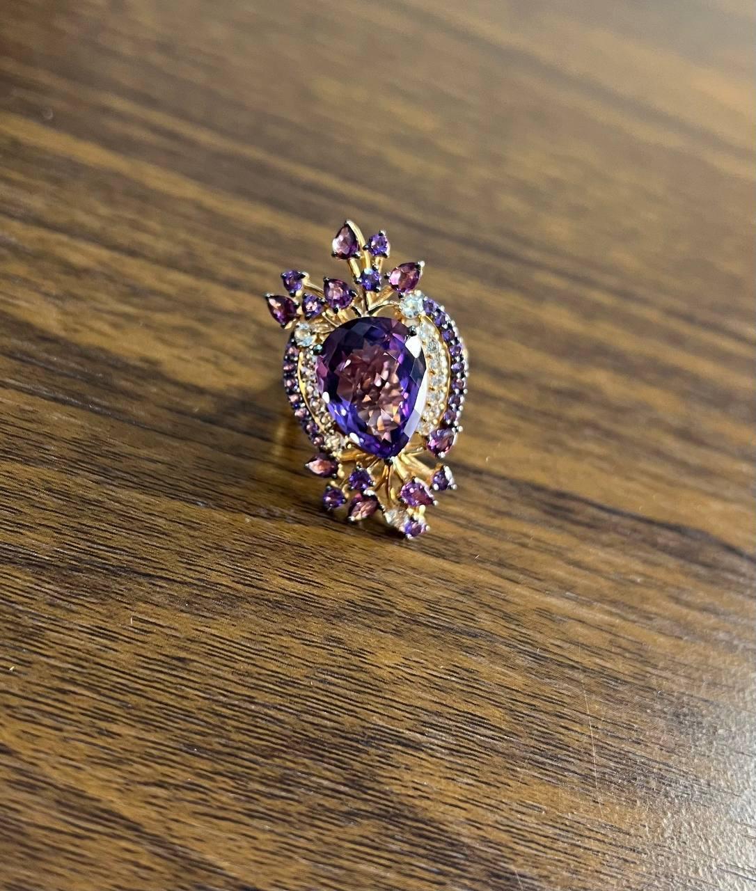 Ein fesselnder Ring mit einem faszinierenden violetten Amethysten in der Mitte.

Dieses exquisite Stück ist aus 14-karätigem Gold gefertigt und bildet ein elegantes und kompliziertes Design.

Das Herzstück des Rings ist ein Amethyst im