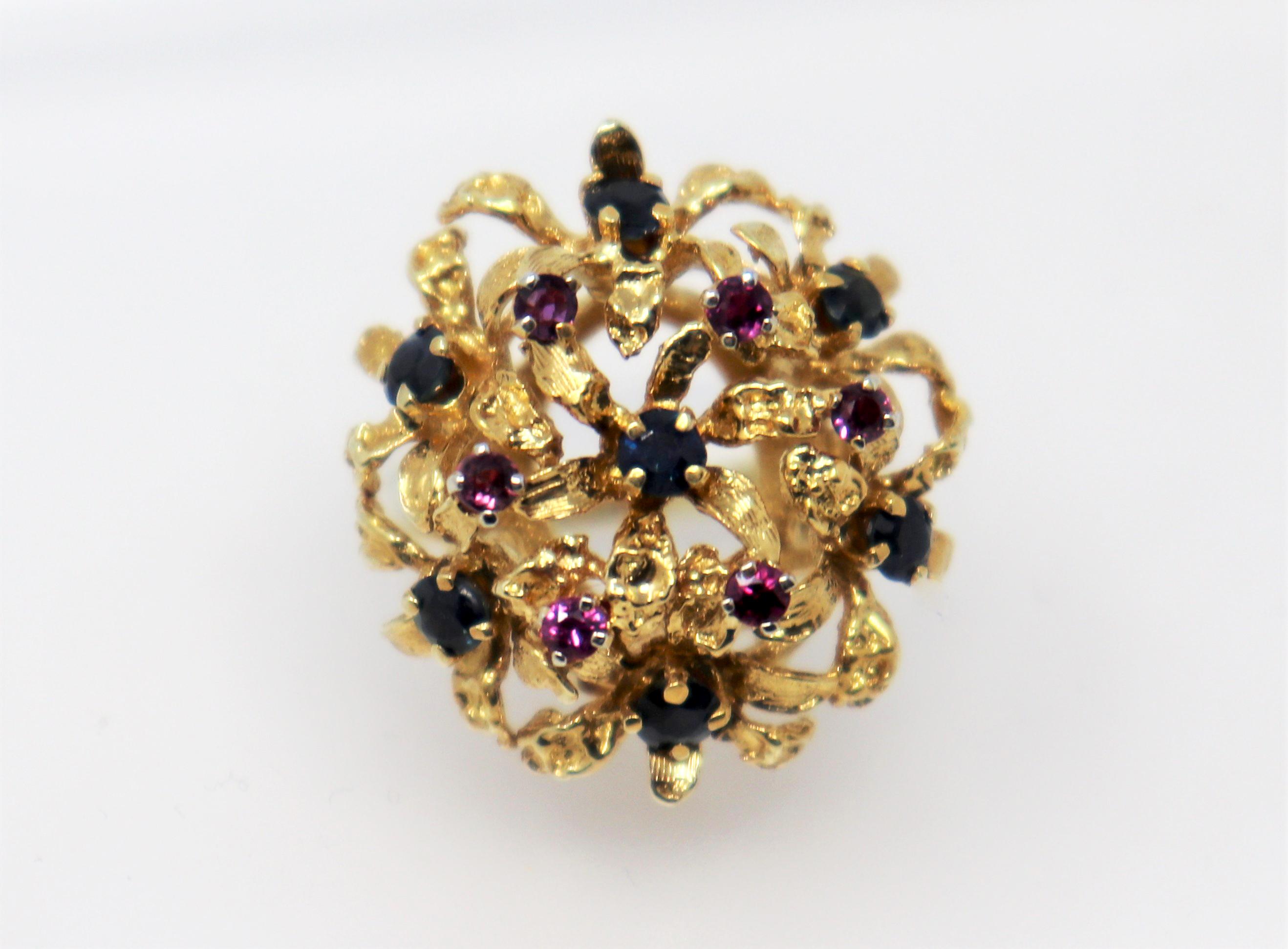 Ring size: 6.75

Lovely vintage cocktail ring bursting with vibrant color. This beautiful piece features a romantic, feminine dome style setting accented by blue and purple sapphires. The colorful rounded cluster with its intricate gold design 