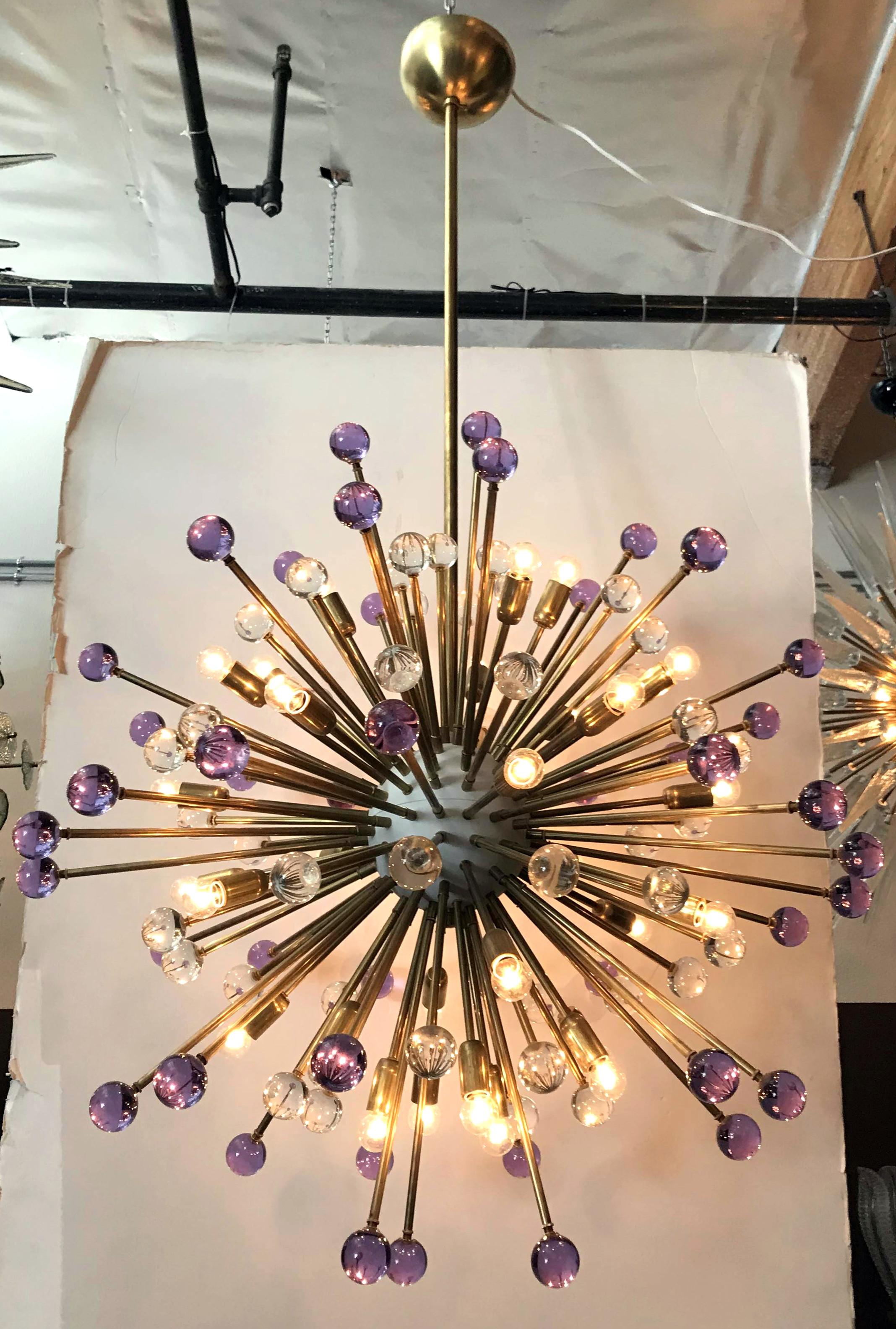 Moderne italienische Sputnik-Kronleuchter mit mundgeblasenen violetten und klaren Murano-Glaskugeln, montiert auf natürlichen Messingrahmen mit weiß emailliertem Zentrum / Entworfen von Fabio Bergomi für FABIO LTD / Hergestellt in Italien
30