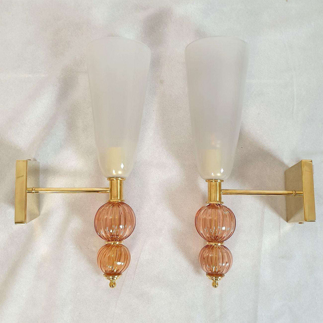 Pair of large Murano glass wall sconces, attributed to Venini Italy 1970s.
The Mid Century Modern sconces have brass mounts.
The square brass back plate is: 4.92 in side.
The Neoclassical style sconces are made of pink/purple and light gray Murano