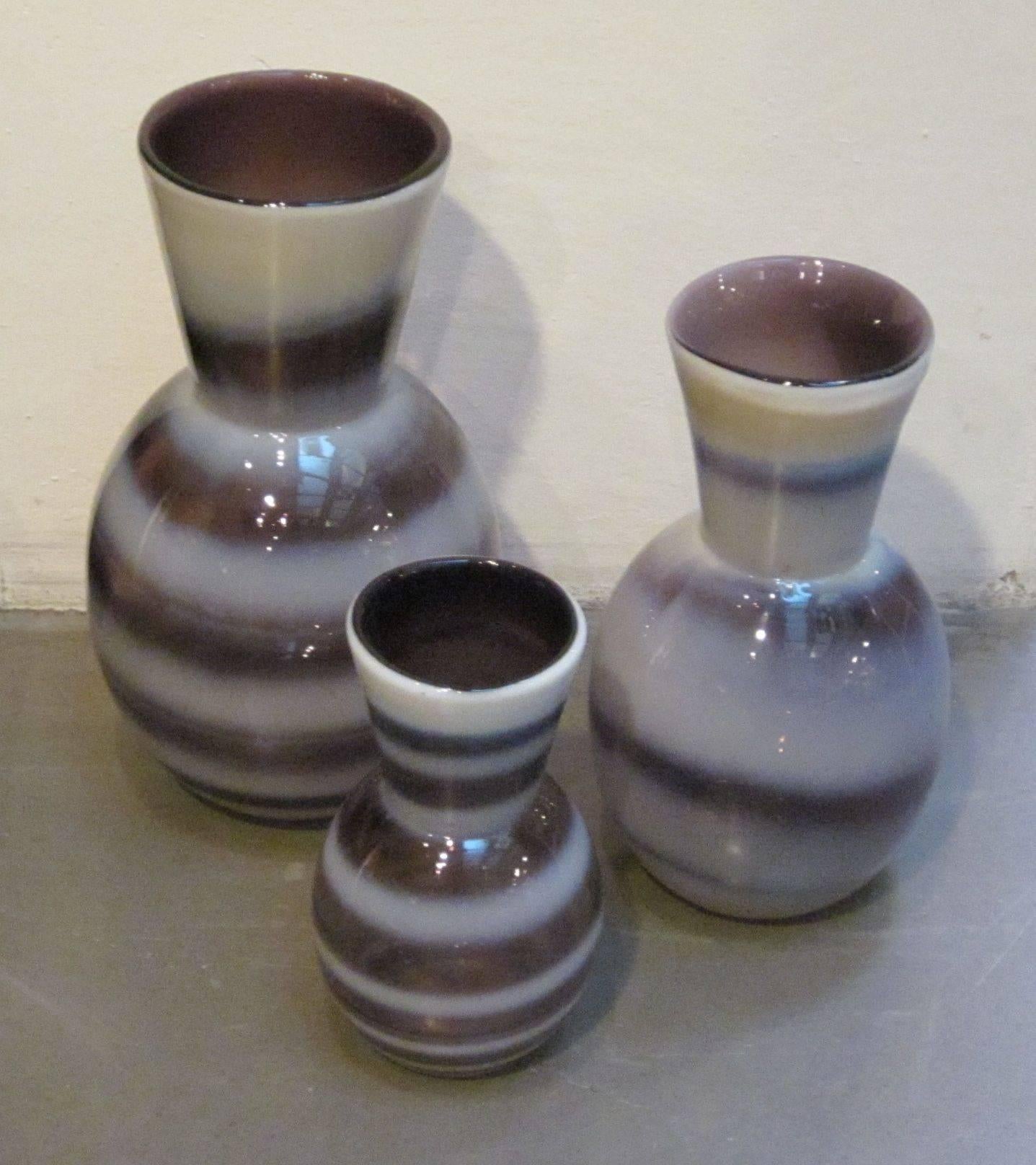 Contemporary Chinese set of three purple and white horizontal stripe glass vases.
Each vase is a different size and stripe pattern.
Sizes are 4