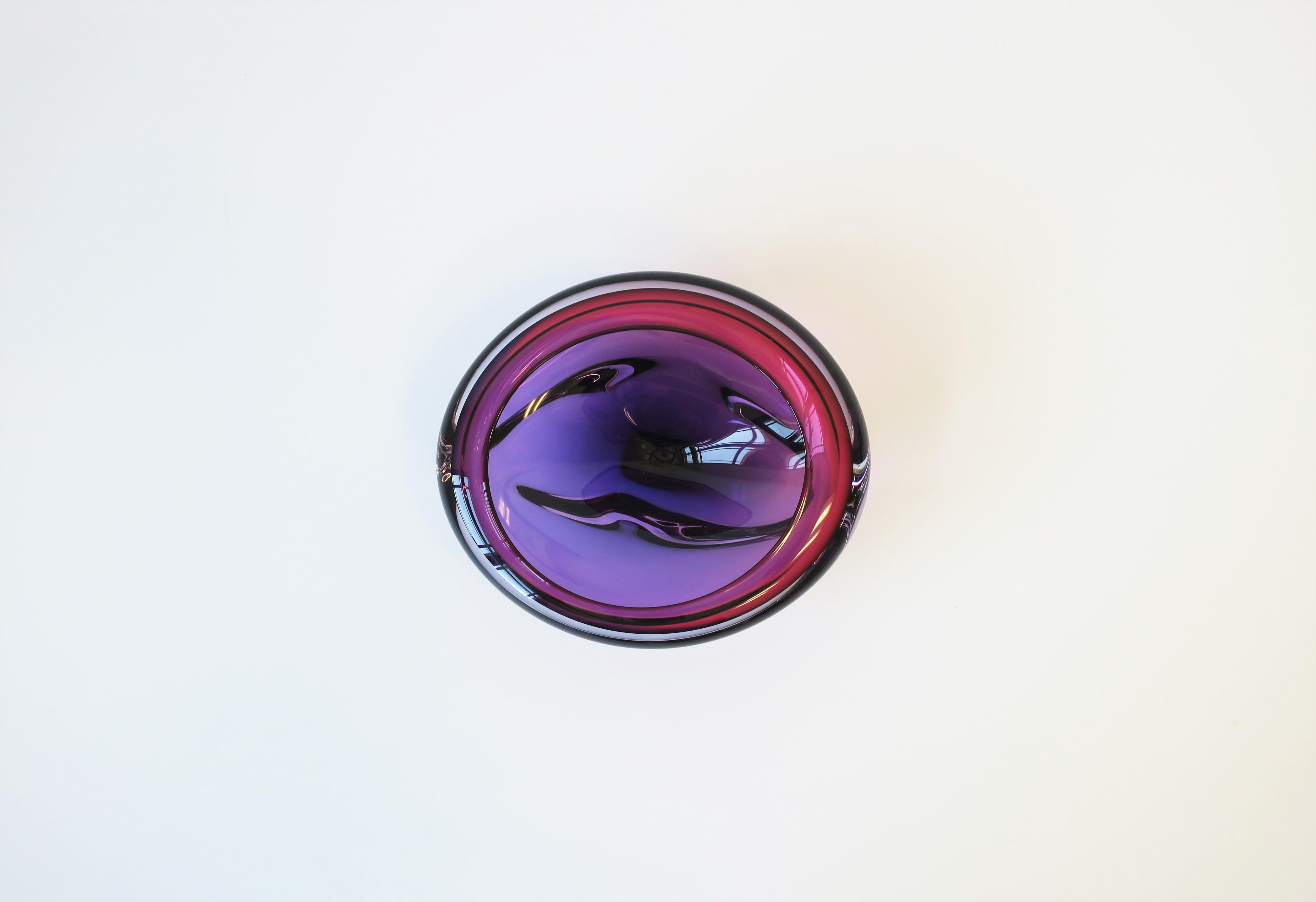 A beautiful and substantial organic modern style art glass bowl, circa late-20th century. Art glass bowl is hand-blown; art glass colors include clear/transparent intertwined with purple and dark pink. Artist signature on bottom as shown in last two