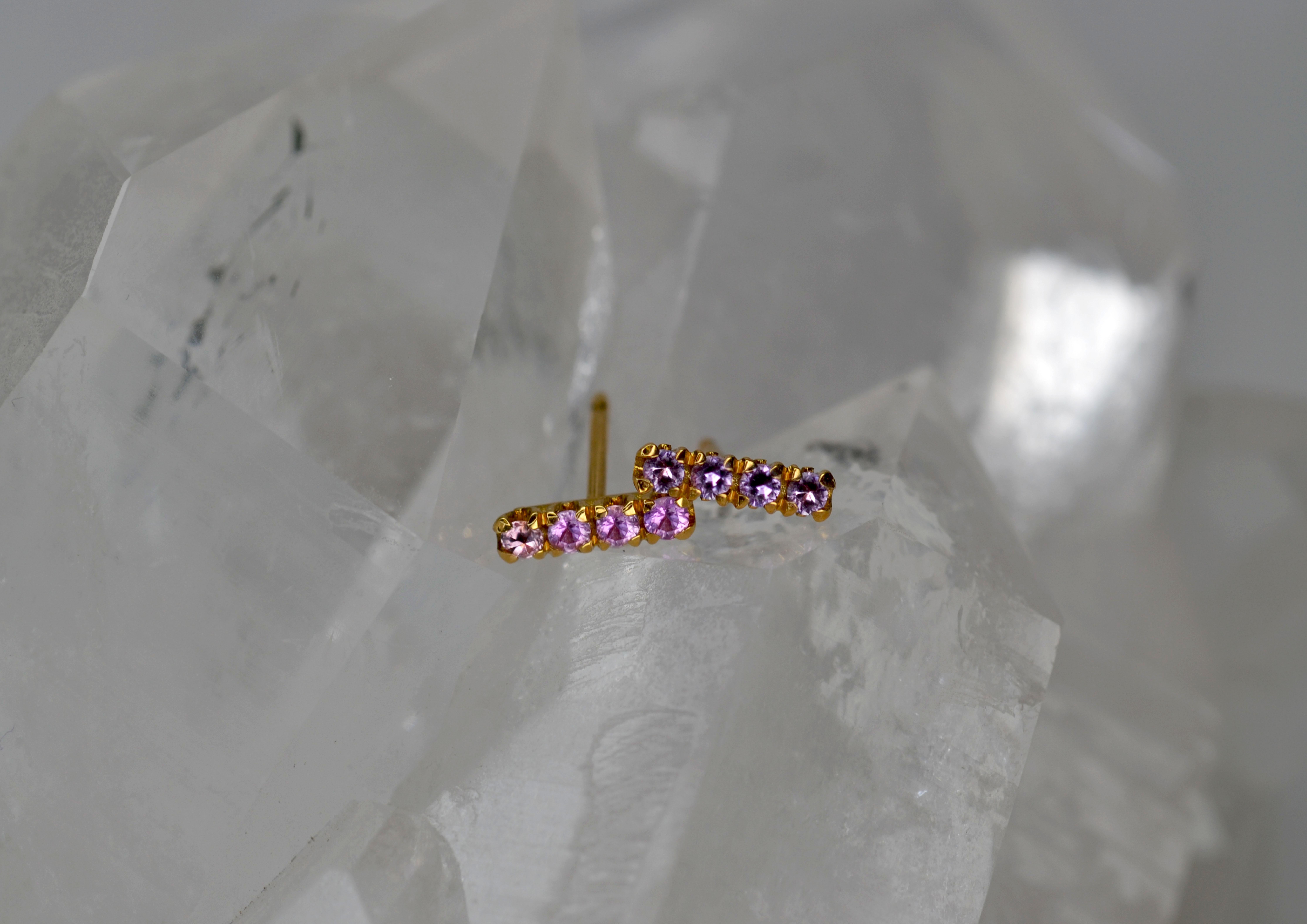 These earring studs are part of our Blossom Collection of mix and match pieces. This playful glittery pair combines purple and pink sapphires set on an 18k gold blossom flower collet, they can be worn alongside your favourite pair of earrings, our