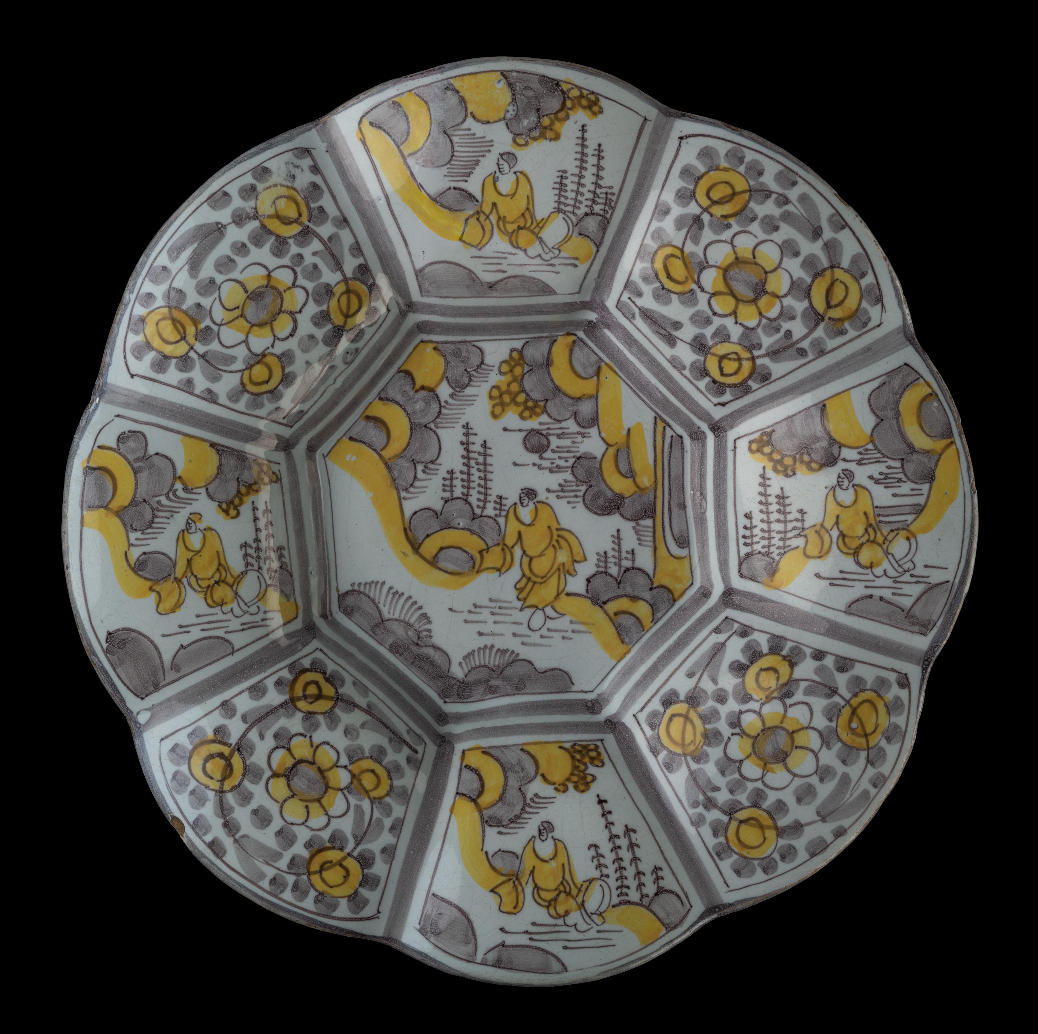 Purple and yellow chinoiserie lobed dish. Delft, 1680-1700 
Dimensions: diameter 34,5 cm / 13.58 in. 

The lobed dish is composed of eight wide lobes and is painted in purple and yellow with a chinoiserie décor. The centre is decorated with a